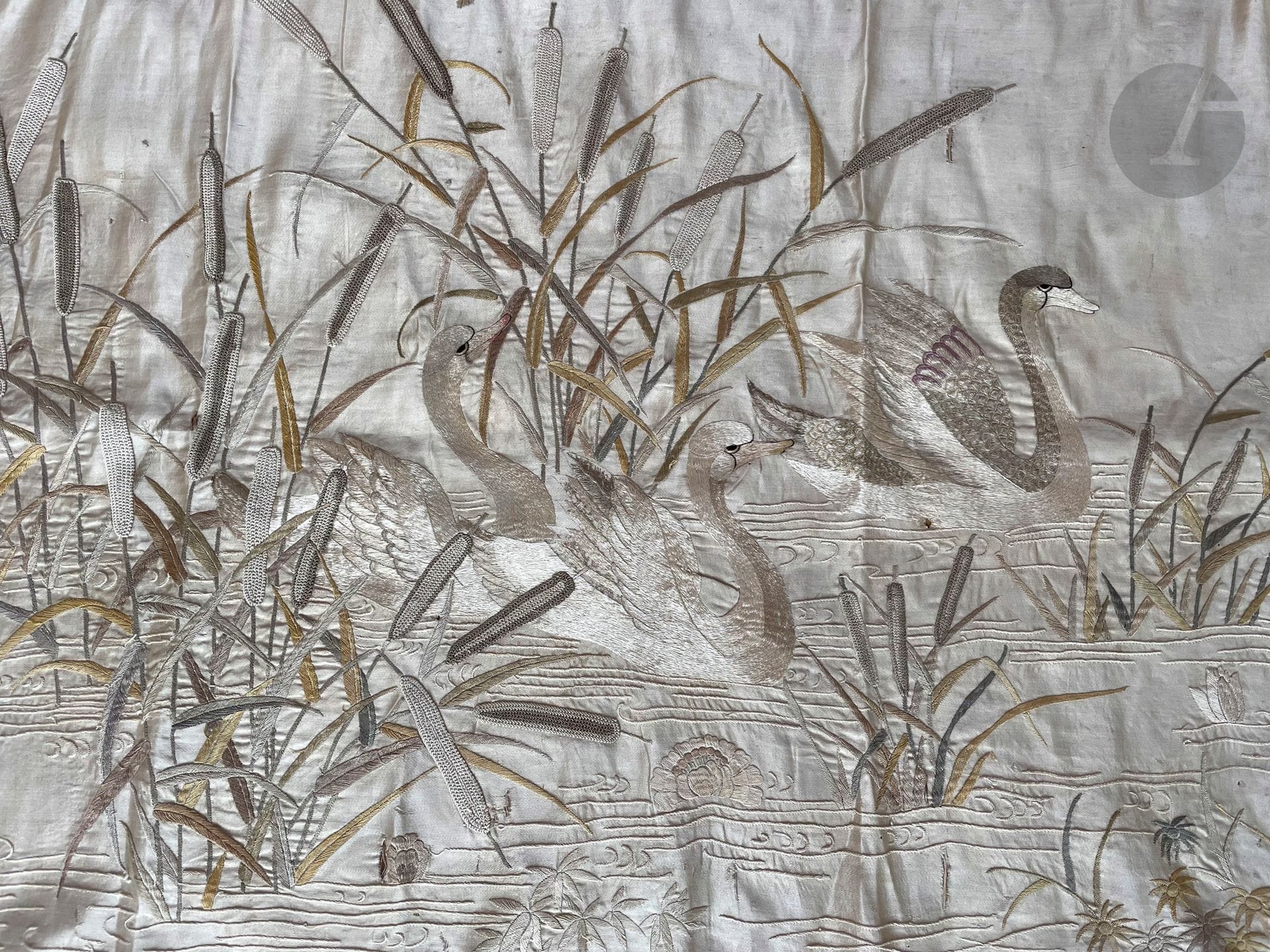 Two silk embroideries in pastel on a silk crepe ground, Japan or Indochina for Europe, late 19th century. Silver-white swans among reeds, silk embroidery in thrown stitch and chain stitch, 50 x 100 cm and cream silk crepe embroidered with scattered bouquets in floche silk, 94 x 180 cm (wear).
