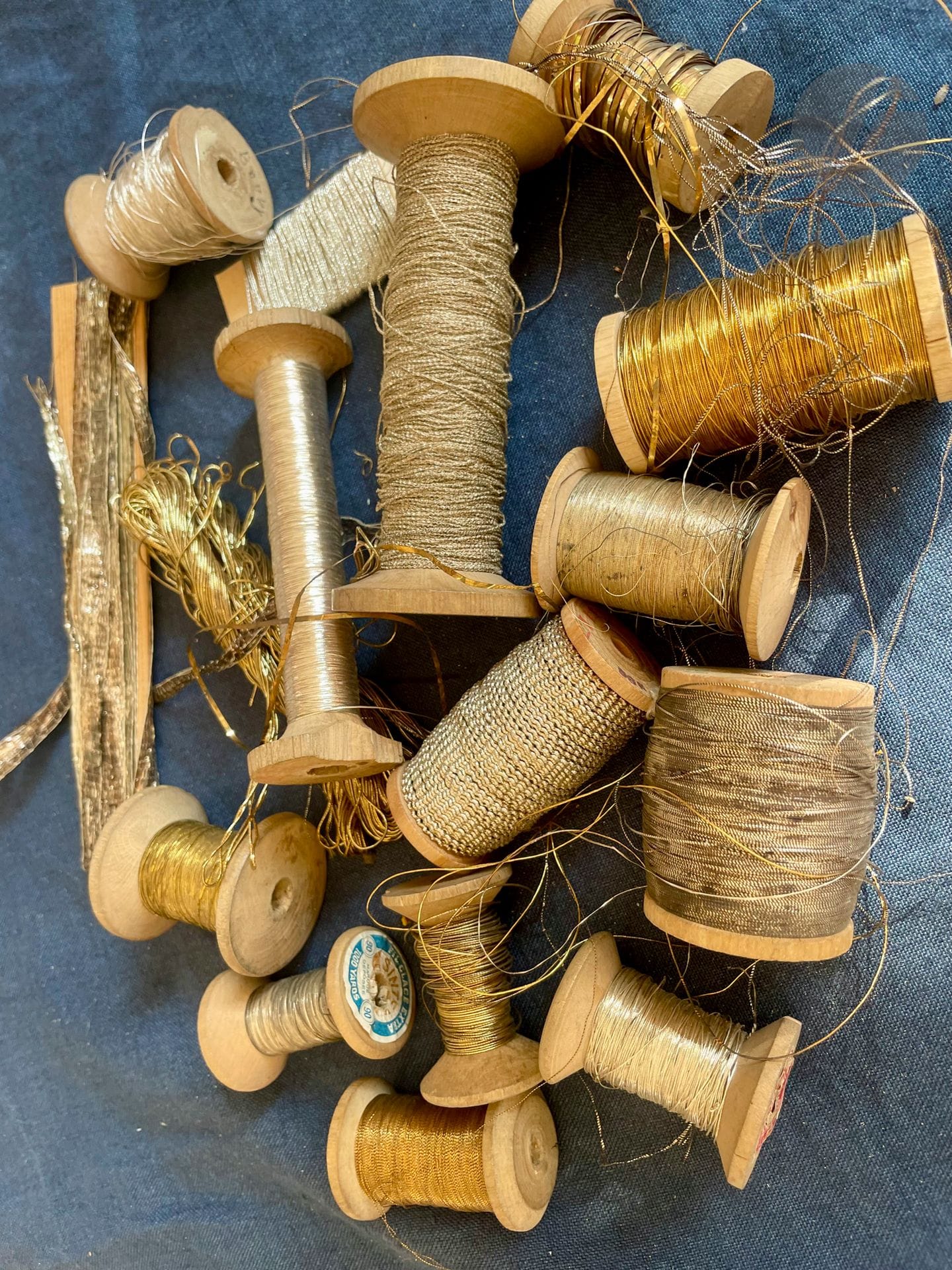 Une quinzaine de bobines anciennes et écheveaux de fils d'or et d'argent pour l'ornement des coiffes Alsaciennes, XIXe siècle. Filé, frisé, lame et tresse d'or ou d'argent sur bobines en bois tourné