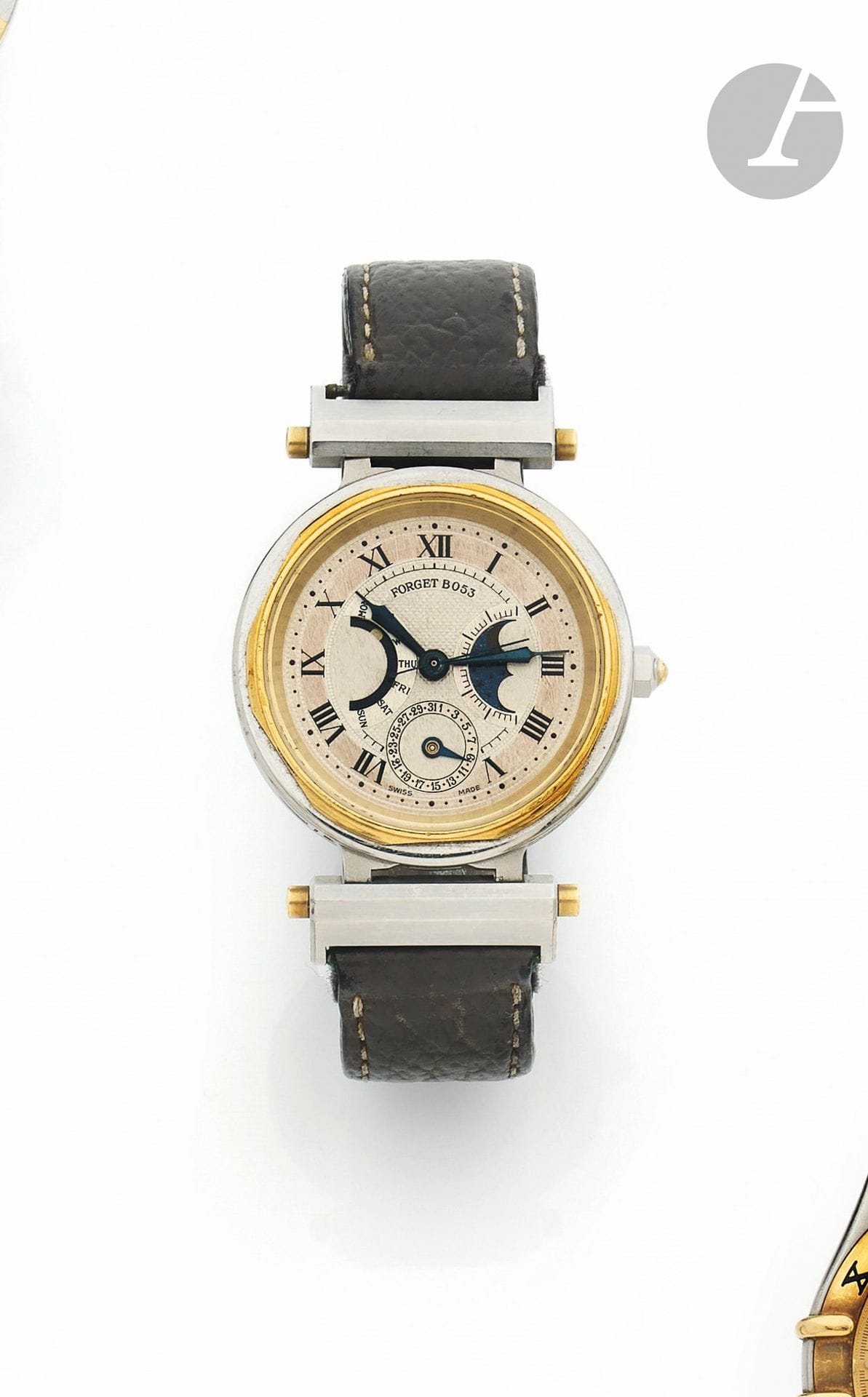 FORGET
ANNÉES 90
Montre bracelet en acier et métal doré avec double quantième et phases de lune. 
Boîtier : rond en acier, lunette métal doré, attaches vissées au boîtier, fond saphir. 
Cadran : argenté et centre guilloché avec index chiffres romains peints, minuterie extérieure. Secteur à 9h pour les jours de la semaine, ouverture pour les phases de lune à 3h et Cadran auxiliaire à 6h pour la date. Aiguilles seringue en acier bleui et seconde centrale.
Mouvement : automatique.
Bracelet : interchangeable en acier et en cuir. 
Cadran, boîtier et mouvement signés. 
Numérotée B053.
Diam. 34 mm