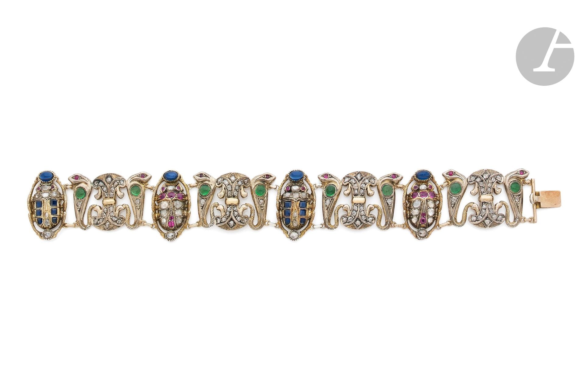 Bracelet en or 14K (585) et argent articulé de motifs inspirés de l'Egypte, de cobras sertis de diamants taillés en roses et d'émeraudes cabochons, de scarabées ornés de diamants taillés en roses, de rubis et de saphirs cabochons, scandés de papyrus agrémentés de diamants. Travail probablement égyptien des années 1950. Dimensions : 20 x 2,3 cm environ. Poids brut : 48,6 g  (égrisures)

A 1950 Egyptian revival bracelet