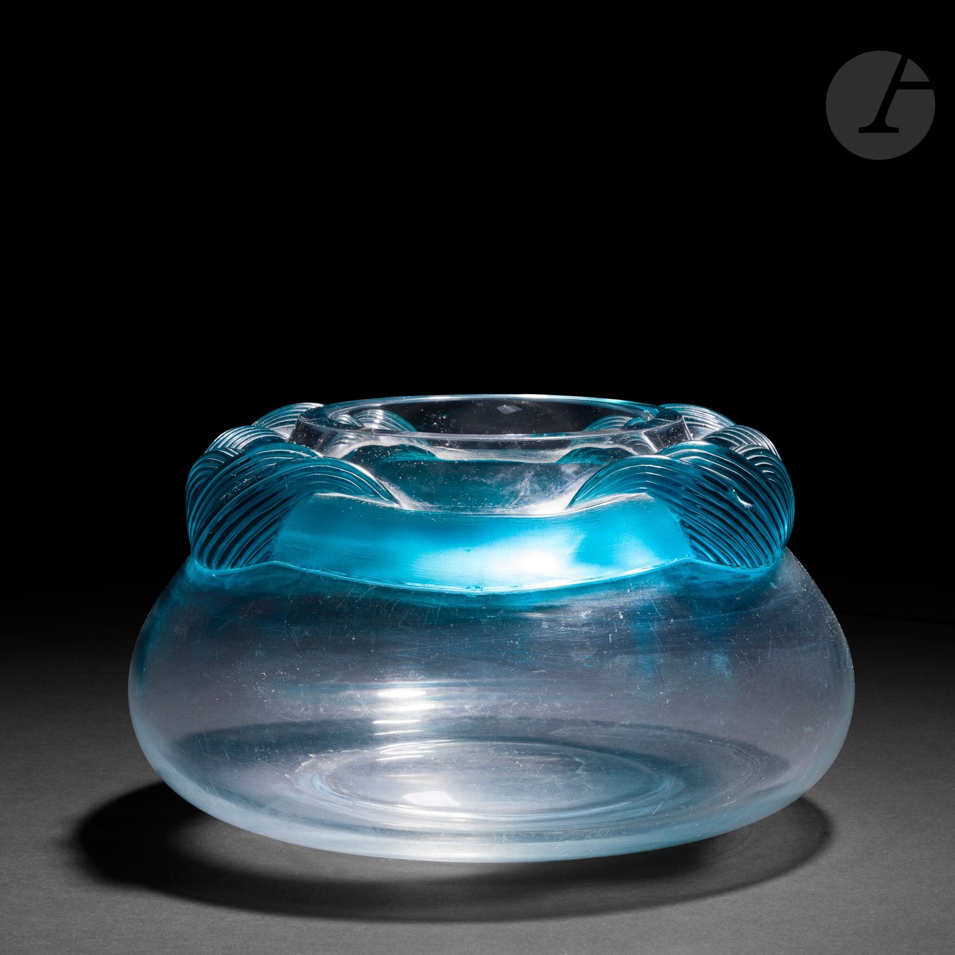 MARIE-CLAUDE LALIQUE (1935-2003) POUR LA MAISON LALIQUE
Cyrus
Vase bursaire. Épreuve en cristal soufflé au décor tournant d’un serpentin rainuré en cristal turquoise appliqué à chaud. Importantes rayures au revers. Signé LALIQUE ® France en lettres cursives à la pointe sous la base. H.15cm – D.28cm