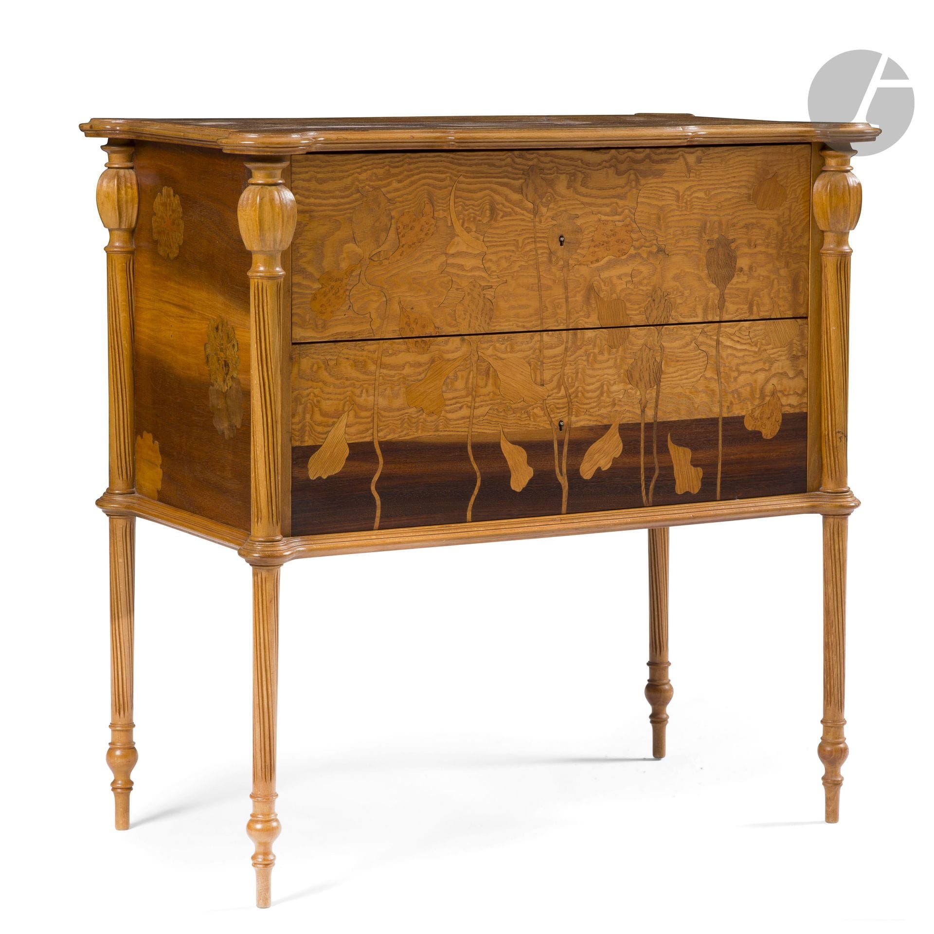 ÉMILE GALLÉ (1846-1904) – COLLECTION MADAME X.
Pavots et Ipomées, le modèle conçu vers [1898], la déclinaison Ipomea présentée à l’Exposition Universelle, Paris, 1900
Élégante commode à deux tiroirs. Les pieds de type Parapluie en hêtre sculpté et nervuré, chacun au chapiteau sculpté d’un bourgeon de pavot, la ceinture basse et le pourtour chanfreiné du plateau en hêtre mouluré. La façade au décor de pavots en marqueterie sur fond de palissandre et de frêne ondé. Le dessus au décor titre double, sous forme de trois cartouches s’imbriquant, en marqueterie de bois précieux et indigènes, certaines parties teintées corail. Les parties latérales recevant également un décor floral en marqueterie de bois précieux et indigènes. Clé en bronze ancienne non d’origine. État et restaurations d’usage. Signée et située GALLÉ Nancy, en marqueterie sur le plateau. H.76cm – L.74cm – P.43cm

Bibliographie:
- Alastair Duncan et Georges de Bartha – Gallé Furniture – Éditions Antique Collectors’ Club, Woodbridge, Suffolk, U.K., 2012. Modèle identique reproduit page327 (planches 11 et 11a). 
- Alastair Duncan – The Paris Salons. 1895-1914. Volume III: Furniture - Éditions Antique Collectors’ Club, 1999. Un modèle identique reproduit page 221.