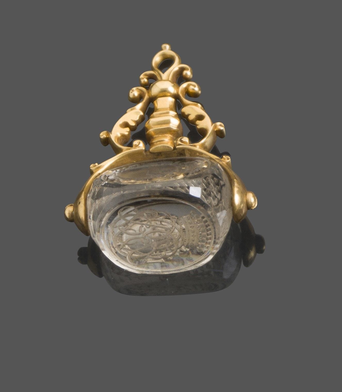 FRANCE XVIIIe siècle
Cachet en cristal de roche en or 18 Kt à trois faces pivotantes et cristal de roche, gravé sur deux faces des mêmes armoiries et sur la troisième d’un chiffre de lettres entrelacées.
Poids brut: 220g - hauteur: 4cm