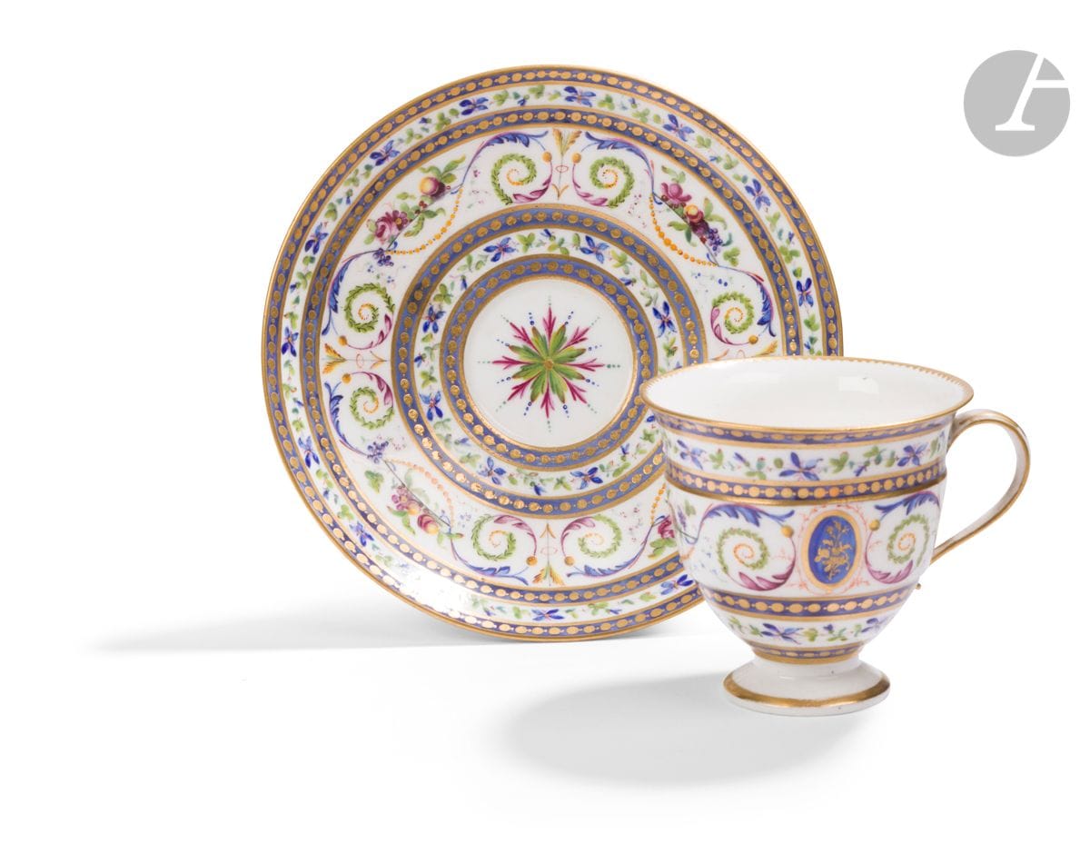 SÈVRES
Bolvry bandeau goblet and saucer in soft porcelain with polychrome decoration of fruit and flower groups, arabesques, foliate scrolls, arrows and pernes between blue-ground braids adorned with strings of gold pearls.
Marked: LL interlaced in gold and gilder's mark Vandé.
18th century, circa 1790.
H. 6.5cm, D. 16cm