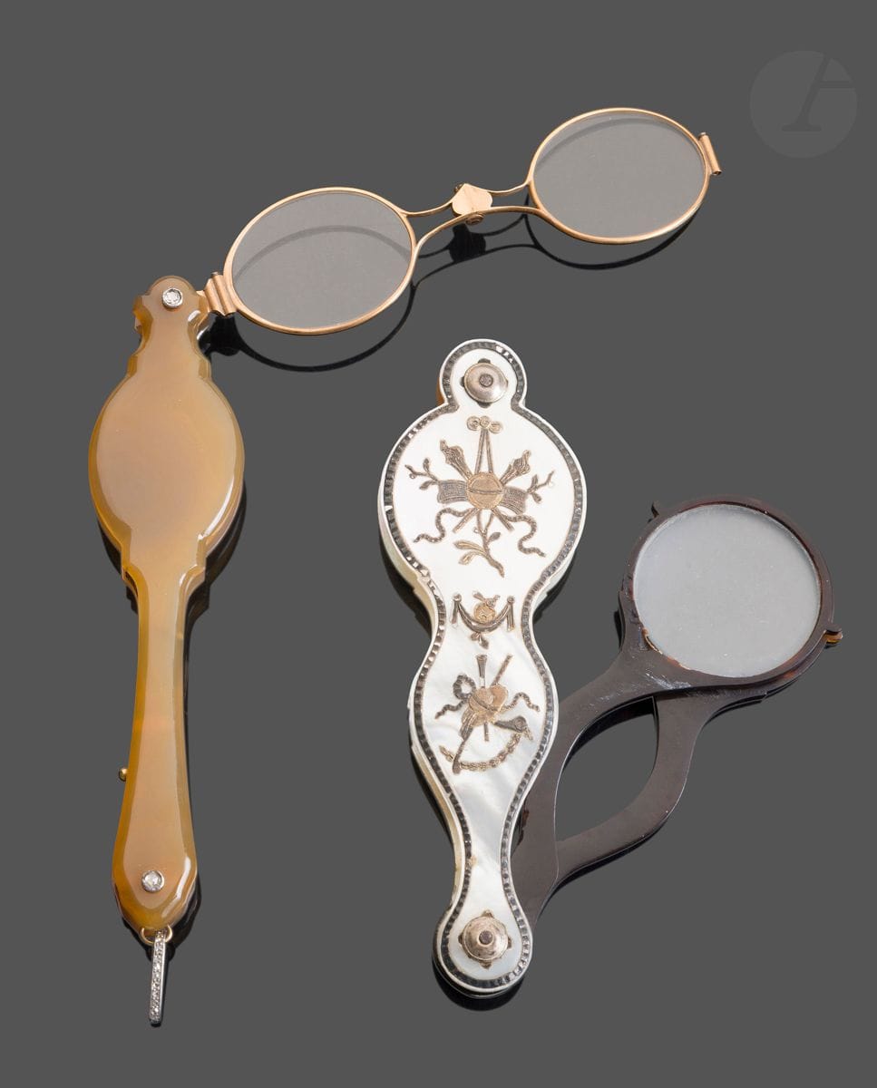 FRANCE 19th century
Face-à-main in agate, 18kt gold, platinum ring, rivets set with rose-cut diamonds.
Marked with an eagle's head
Gross weight: 54g - length: 14cm
Condition: new
A violin-shaped face-à-main in mother-of-pearl and tortoiseshell, with applied decoration of musical instruments and ribbon bows in the Louis XVI style.
Length: 12.5cm - width: 4cm -
Condition: chips to the mother-of-pearl, moth holes to the tortoiseshell