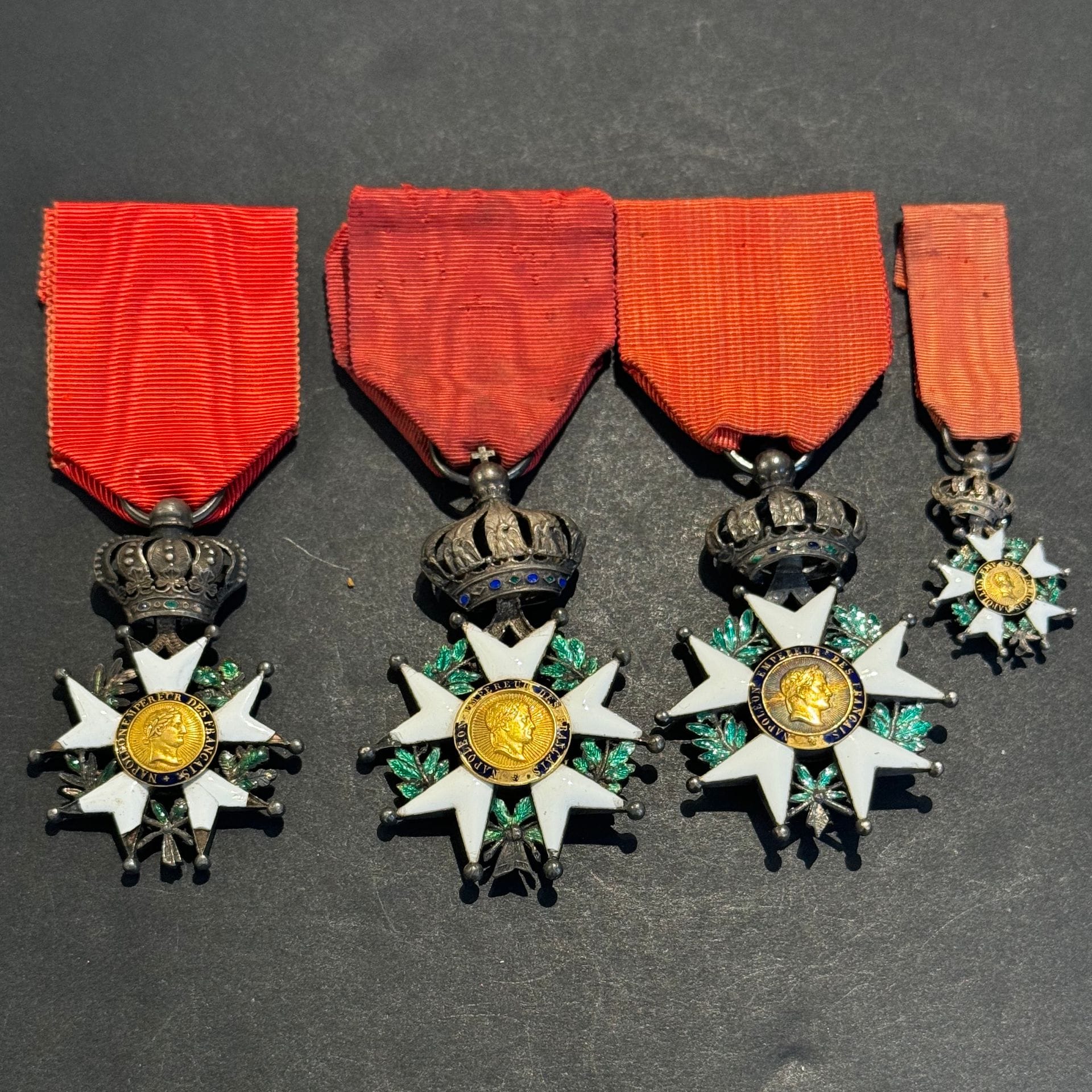 FRANCE 
ORDRE DE LA LÉGION D’HONNEUR 
Quatre étoiles de chevalier : 
- deux étoiles d’ordonnance d’époque Second Empire. Argent, or et émail (éclats). Rubans. B et T.B. 
- une réduction d’époque Second Empire. Argent or et émail (éclats). Hauteur : 35 mm. T.B. 
- une réduction d’époque Présidence. Argent, or et émail (manques). Hauteur : 50 mm. B