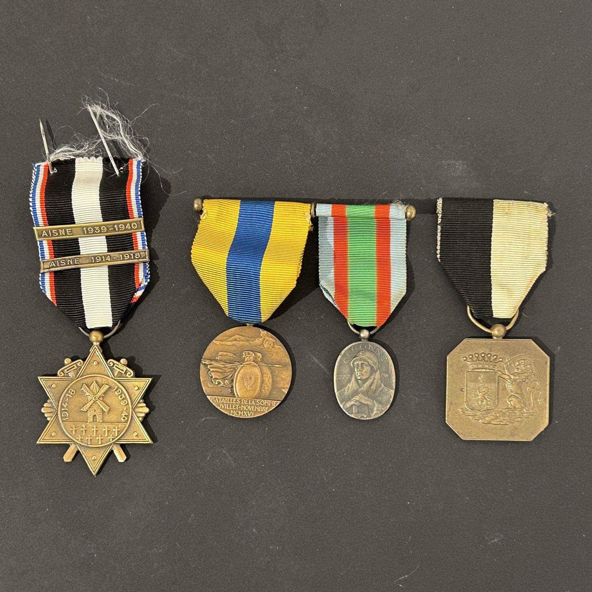 FRANCE - BELGIQUE 
Quatre médailles commémoratives de la 1re guerre mondiale : 
- médaille du Chemin des Dames. En bronze. Ruban à agrafes « AISNE 1914-1918 » et « AISNE 1939-1940 » 
- médaille de Charleroi de l’association Franco-belge. En bronze. 
- barrette de deux médailles : Médaille de l’Argonne du 1er type. En bronze. Médaille de combattants de la Somme. En bronze. 
Rubans. On y joint une boîte du fabricant Drago.