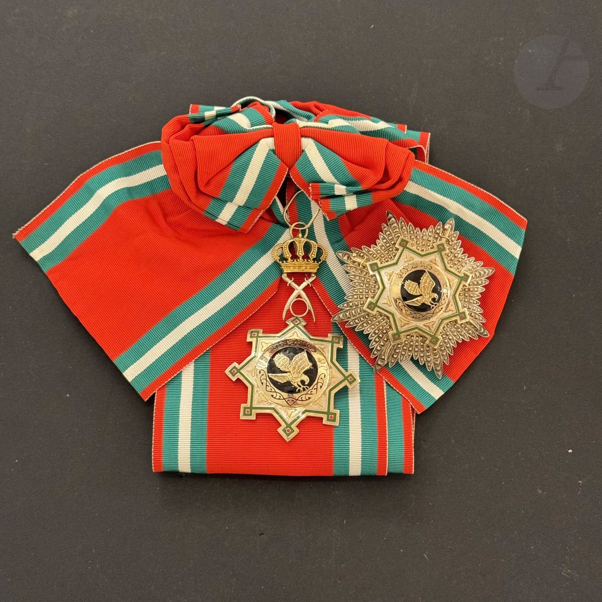 JORDAN 
ORDER OF THE FALCON. 
Silver grand-cross set including : 
- silver, vermeil and enamel jewel. Silver, vermeil and enamel (small chips). Scarf with bow. 92 x 58 mm - Gross weight: 44 g
- Silver, vermeil and enamel plate. 75 mm - Gross weight: 104 g
T.T.B.

Lot sold by appointment, collection available on Friday, December 06.