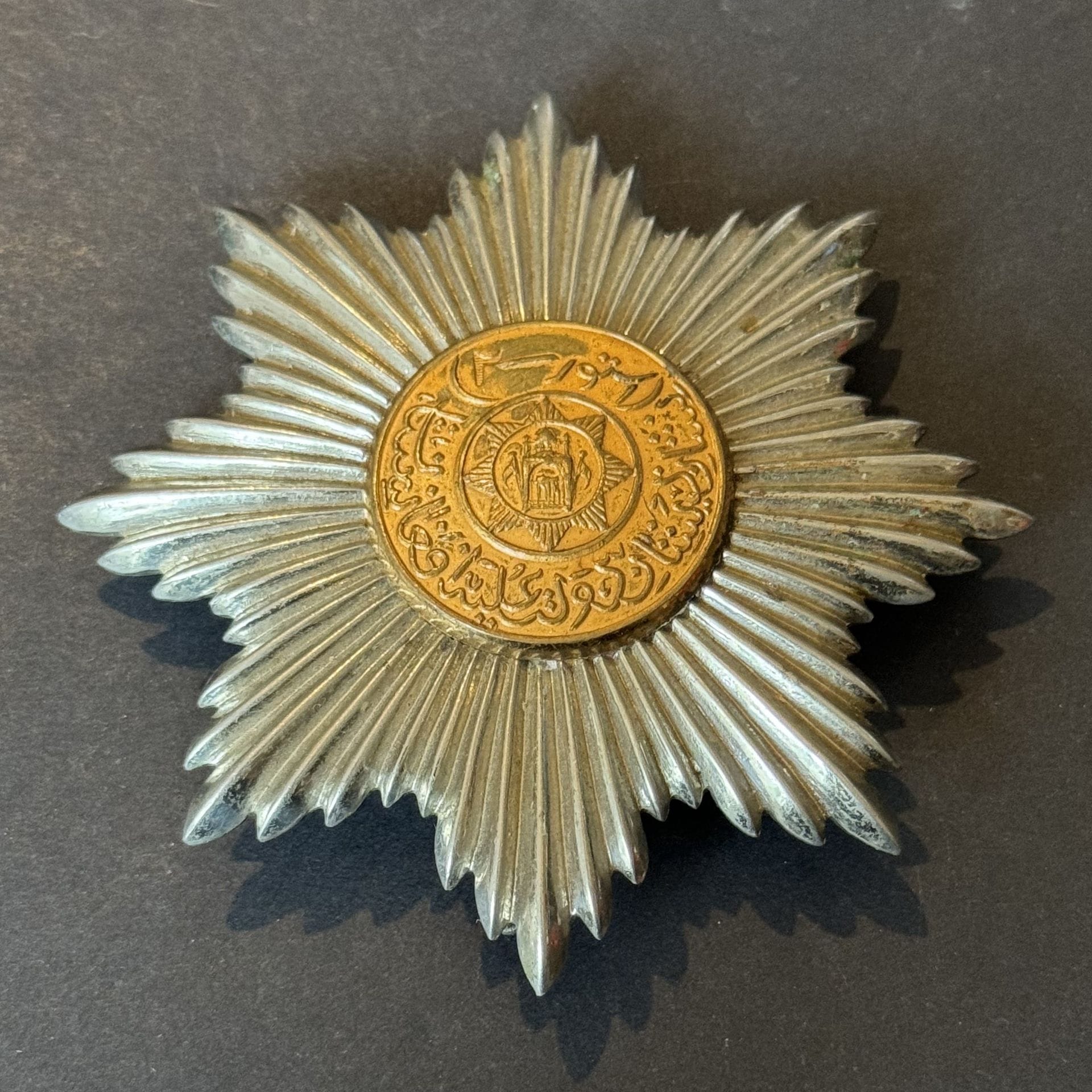 AFGHANISTAN
ORDRE DU SOLEIL
Plaque de grand-croix en métal argenté et doré. 
Revers à attache basculante. 
Diamètre : 78 mm
T.T.B.