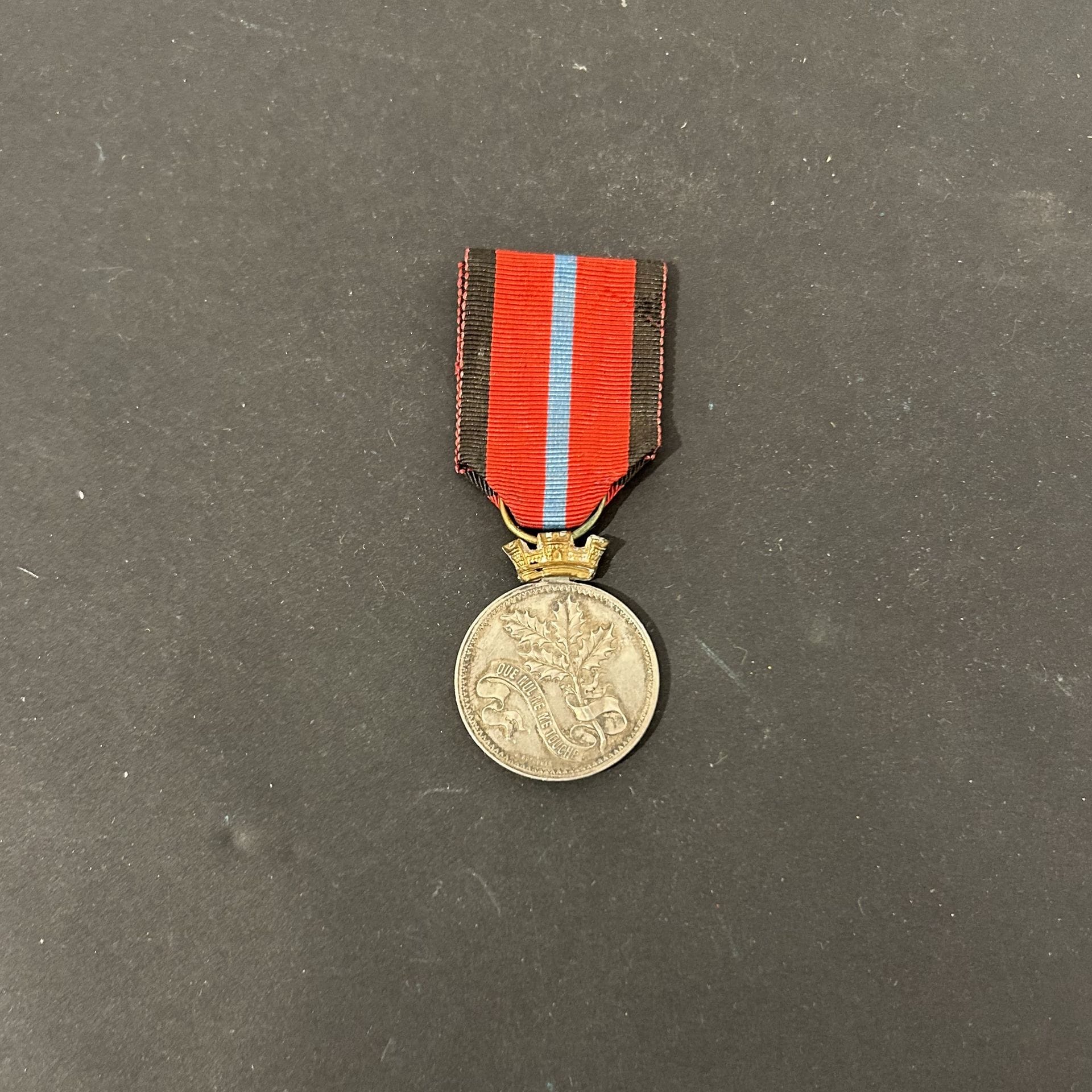 FRANCE 
Médaille de la Société des Volontaires 1870-1871 dite « à la branche de houx ». 
En argent. Attribuée à « E. DRIARD. MEDECIN MAJOR ». 
Poinçon « argent » sur la tranche. Couronne en laiton doré. Ruban. 
Diamètre: 27 mm - Poids brut : 11 g
T.T.B.