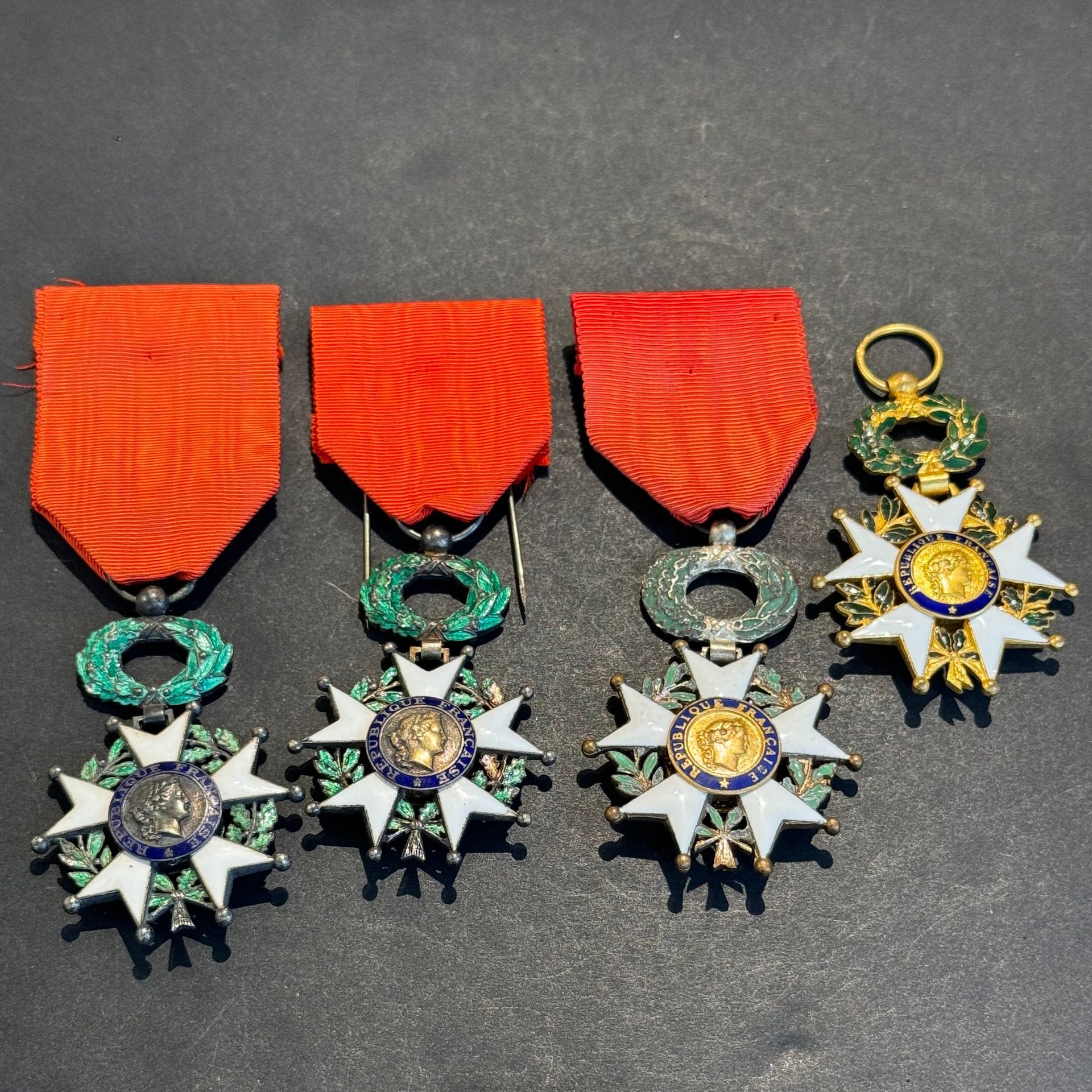 FRANCE 
ORDRE DE LA LÉGION D’HONNEUR 
Ensemble de quatre étoiles de chevalier de la Légion d’honneur IVe République. 
Métal argenté et doré, deux en argent poinçonnées de la Monnaie de Paris. Trois avec rubans. 
T.B.