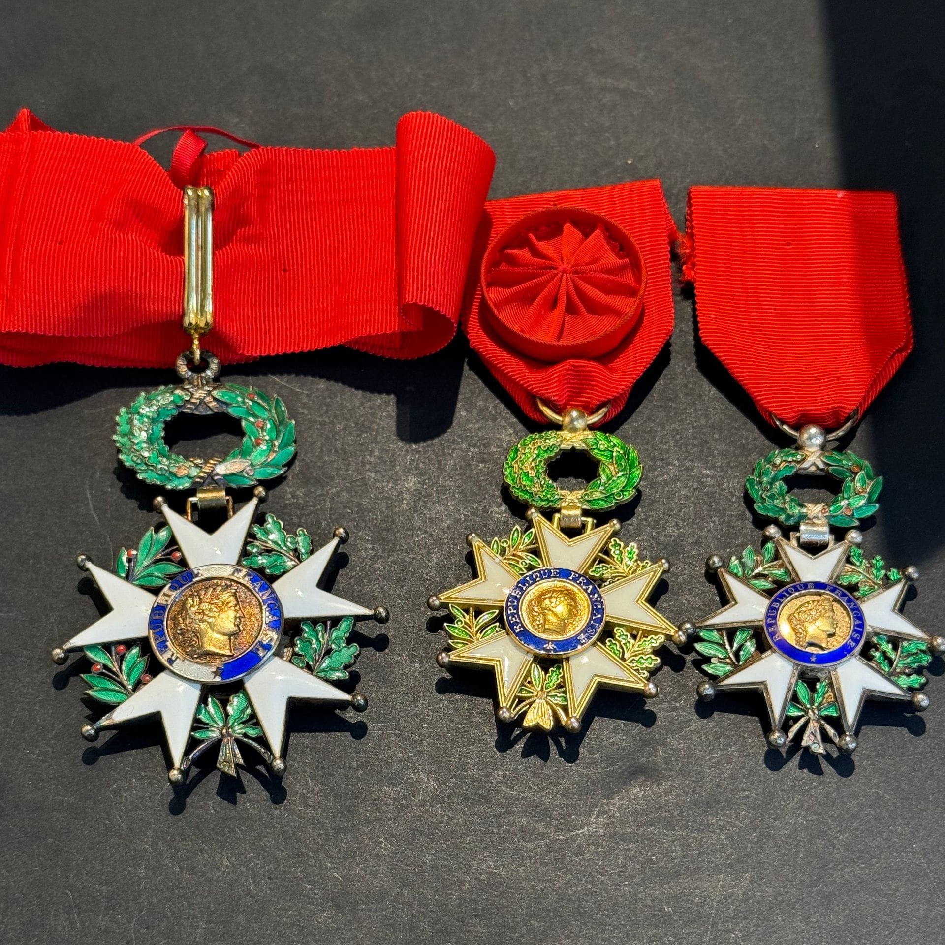 FRANCE
ORDRE DE LA LÉGION D’HONNEUR 
Ensemble de trois pièces d’époque Ve République : 
-étoile de commandeur en vermeil et émail (éclats). Cravate. Poinçon au crabe et d’orfèvre Arthus Bertrand. B à T.B. 
- étoile d’officier en métal doré. Ruban rosette. T.T.B. 
- étoile de chevalier, modèle à filets. Argent, vermeil et émail. Centre en deux parties. Poinçons au crabe. Ruban. T.T.B.