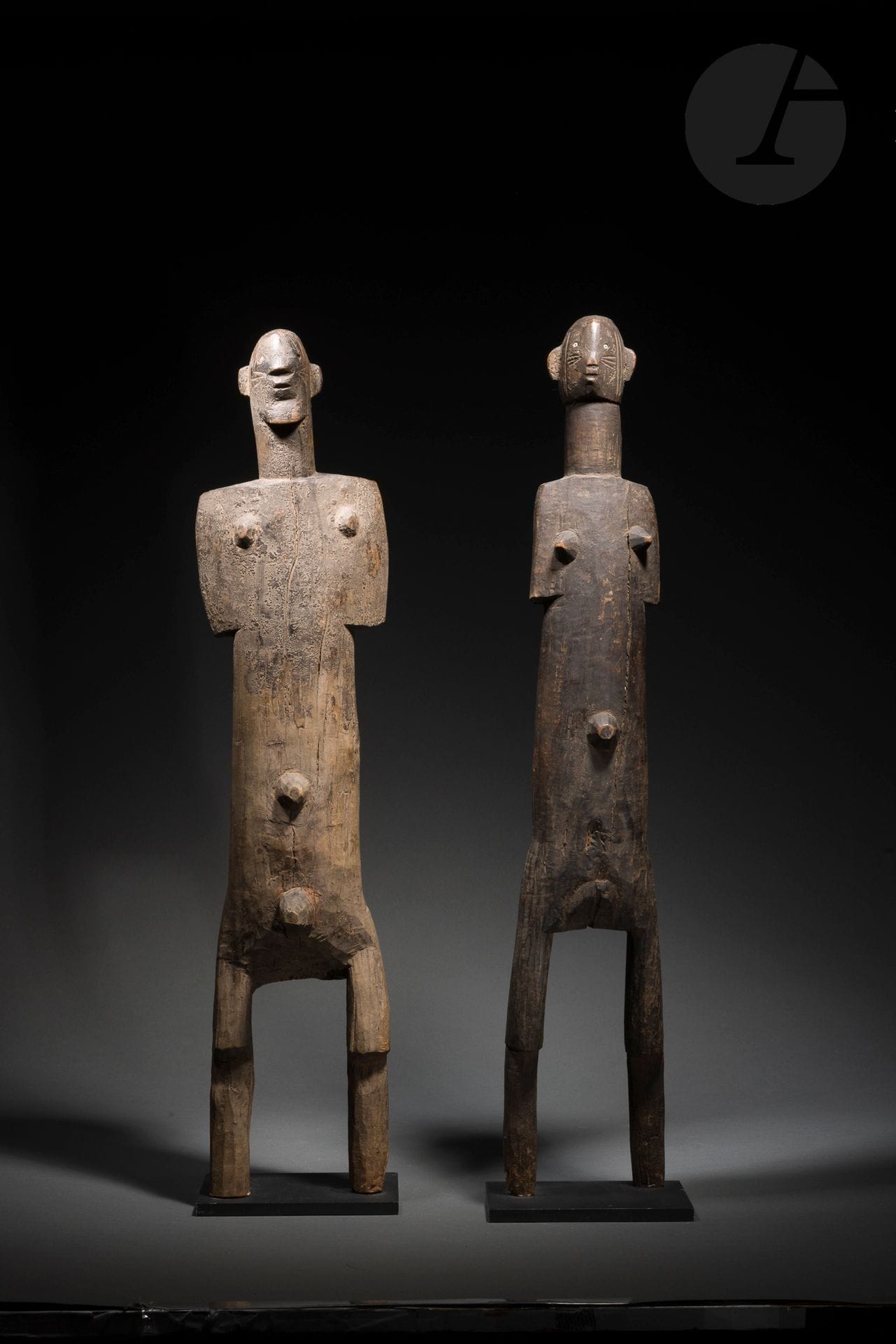 Un ancien couple de statues masculine et féminine, leurs sexes sont clairement signifiés, leurs visages scarifiés, les yeux sont indiqués par des perles incrustées. Ces deux sculptures très expressives comptent parmi les rares et très beaux témoignages de l’art si singulier des peuples Nyamwési. «Ces rares sculptures accompagnaient - d’après Nancy Nooters - les sièges à haut dossier des chefs d’Iramba.» (Commentaire dans les archives Hélène Leloup). 
Voir la vente de la Collection Walter Bareiss, Neumeister, 13 novembre 2008, pour un autre rare couple niamwezi (lot n°1270). 
Niamwezi, Tanzanie
Bois dur, perles dont une manquante, fentes d’ancienneté, tronquées en partie basse, un manque visible à l’arrière de la figure masculine (casse ancienne), très belle et ancienne patine d’usage. 
H.: 69,5 et 70, 5cm 

Provenance: 
Collection Hélène Leloup, Paris
Transmis par descendance