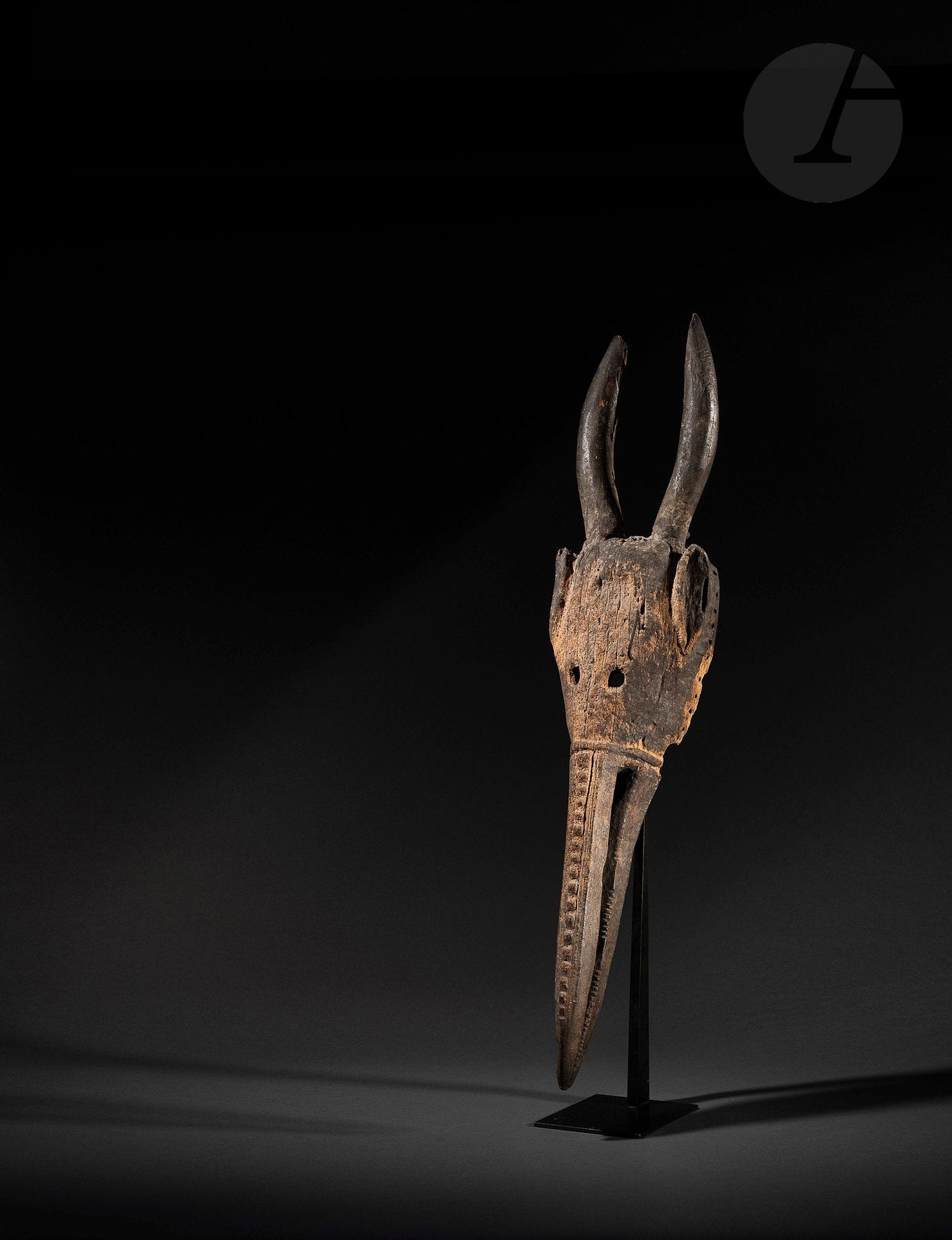 A very old and rare anthropo-zoomorphic koma ba mask with a long bird's beak and horns. This much-feared type of mask was borrowed by the Kono of Guinea and other Dan groups, but originated in this region from the Maou living in the border zone between Guinea, Côte d'Ivoire and Liberia. But its ancient origins can certainly be traced back to the Komo mask of the Bambara, who spread their ancestral traditions around the 17th century at the time of the great southward expansion of the old Mandingo empire, and whose cultural and artistic influences can be seen as far as the sea and in all the forests of this region.
Dan-Maou or Tura, Guinea or Ivory Coast,
early 20th or 19th century
Wood, iron, very fine old oxidation and very fine old patina.
Height: 105cm 

Provenance: Renaud Vanuxem, Paris
Renaud Vanuxem, Paris 
Stéphane Kurc Collection, Paris

Exhibition and publication: 
4th International Tribal Art Show, 2001, p.55
