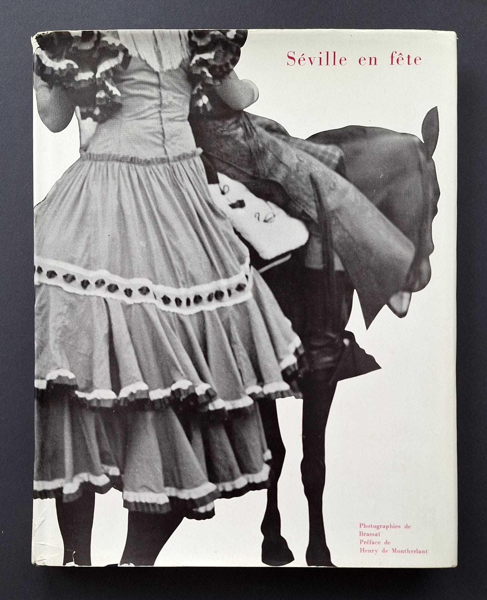 BRASSAÏ (GYULA HALÀSZ, KNOWN AS) (1899-1984) 
Seville in celebration.
Robert Delpire Éditeur, Collection Neuf, 1954.
In-4 (27.5 x 22cm). First edition. 156 pp. Preface by Henry de Montherlant. Unpublished texts by Dominique Aubier.  Heliogravure photographs. Publisher's blue cloth binding in illustrated dust jacket. Very small loss at top of rear dust jacket; name on title page and flyleaf.