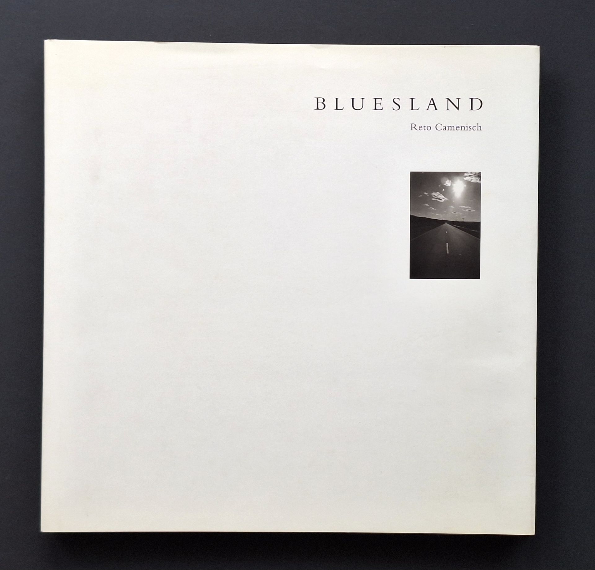 CAMENISCH, RETO (1958) [Signed]
Bluesland.
Ott Verlag, Thun, 1997.
In-4 (29 x 29 cm). Édition originale, numérotée et signée par Reto Camenisch en page de garde. Texte de Margret Mellert. Reliure en tissu avec petite étiquette photographique sur le 1er plat, sous jaquette illustrée.