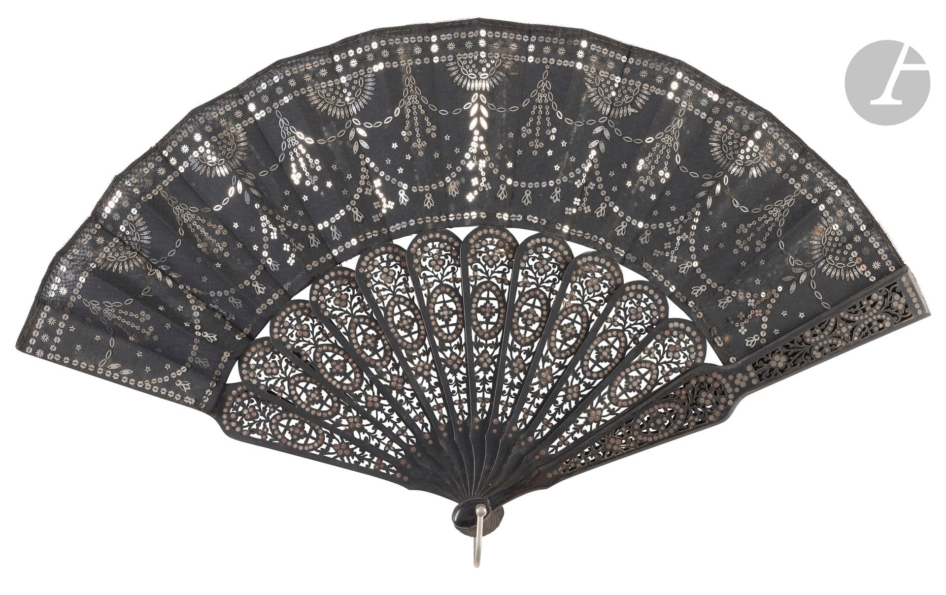Deux éventails, Europe, vers 1880-1890
*L'un, la feuille en gaze noire brodée de paillettes argentées dessinant des guirlandes et des demi soleils.
Revers muet.
Monture en bois noir, découpé d'un motif répété, rehaussé de paillettes argentées.
Bélière métallique.
H.t. 27,5 cm-H.f. 11 cm (petits manques, oxydations, et taches d'humidité)
Dans une boite portant sous le couvercle l'adresse de l'éventailliste parisien Geslin, Maison dorée.
*L'autre, la feuille en gaze peinte d'une demoiselle pêchant, installée dans un arbre. 
Revers muet.
Monture en bois partiellement laqué blanc, et estampé et doré d'un décor de colonnes. Bélière métallique dorée. 
H.t. 35,5 cm-H.f. 21,5 cm (taches, coupures)
Dans une boite.