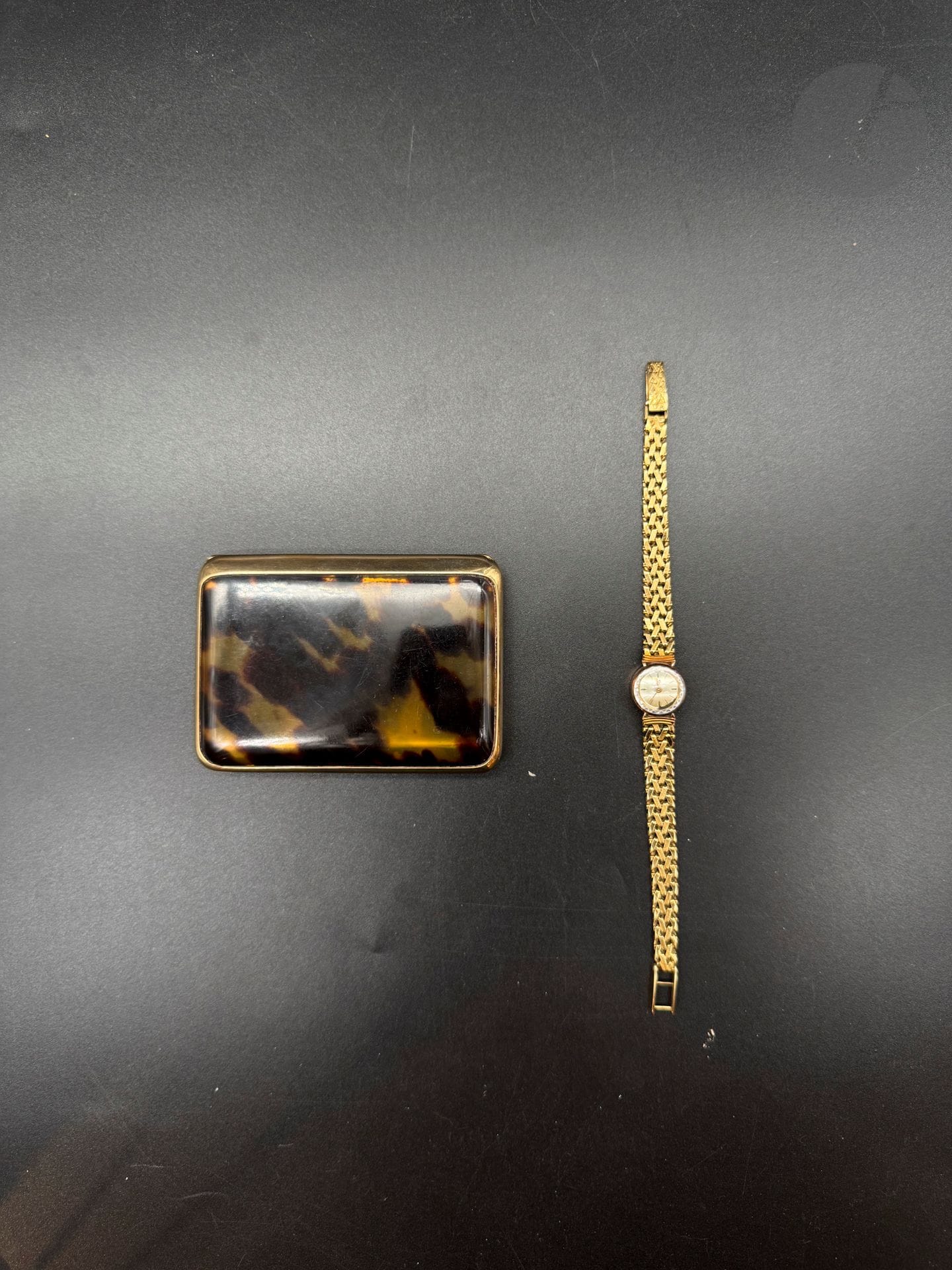 LIP. Montre bracelet de dame en or 750/°°°, bracelet tressé or 750/°°°
Poids brut : 24 g
On joint une boite en bakelite cerclage or 375/°°°, poids brut : 50,3 g
débris