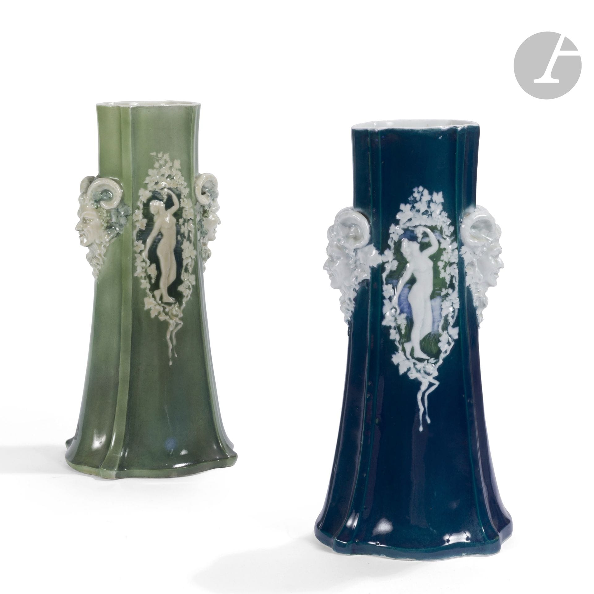 MANUFACTURE DE PORCELAINE D’ALFORTVILLE
Bacchanales, 1916
Deux importants vases tronconiques nervurés formant pendants. Épreuves en porcelaine émaillée; l’une en vert, l’autre en bleu marine. Les décors de nus aux grappes de raisin et de têtes de satyre en relief et émaillés blanc. Le vase vert marqué du cachet de la manufacture, le vase bleu daté 7 juin 1916 au revers. H. 40,5 cm