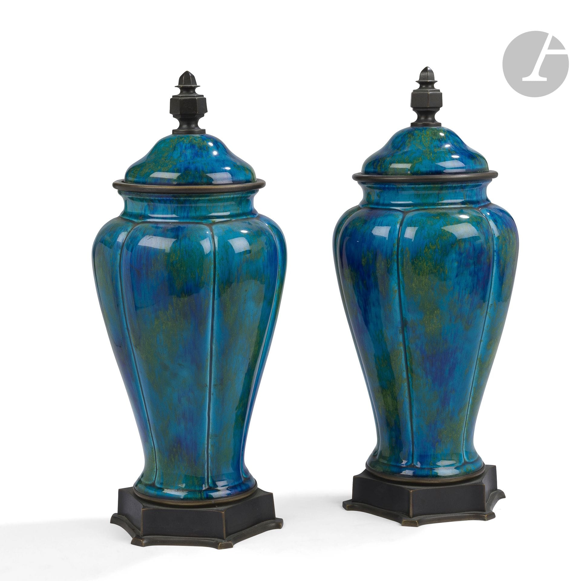 PAUL MILLET (1870-1950) CÉRAMIQUES D’ART À SÈVRES
Importante paire d’urnes balustres, couvertes et montées; à l’évocation de l’Asie. Épreuves en céramique émaillée bleu canard; les bases, les pourtours et les prises en bronze patiné. Chacune complète de son intérieur. Époque Art déco. Chaque couvercle monogrammé M. P. Sèvres au revers. H. 43,5 cm