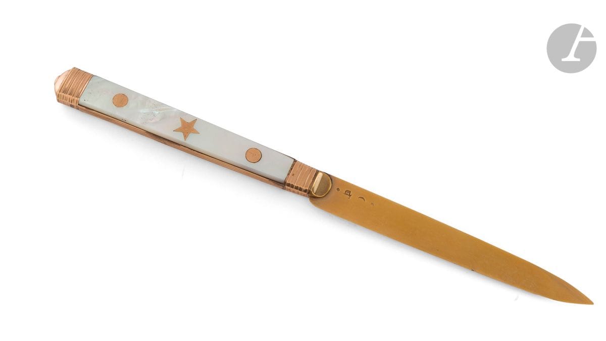 FRANCE début du XIXe siècle
Couteau en nacre et lame en or. Le manche en nacre est rehaussé d'un décor de deux pastilles d'or encadrant une étoile sur les deux faces dont l'une est gravée d'un chiffre de lettres entrelacées.
Poinçon de maître illisible commençant par un " j ". Repoinçonné à la tête d'aigle
Poids brut : 49 g - longueur : 19,7 cm