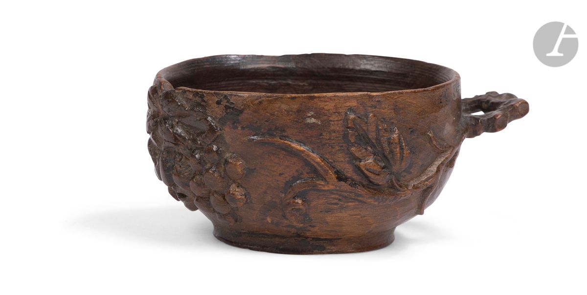 *FRANCE XIXe siècle
Tasse à vin/tassou en bois teinté à décor sculpté d'une tête de Bacchus encadré de pampres de vigne se prolongeant sur l'anse. Au revers grand monogramme BF.