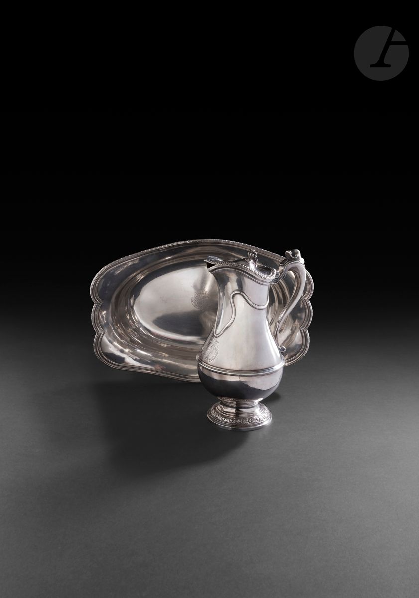 PARIS 1771 - 1772 and 1772 - 1773 (date letters H and I)
Baluster ewer and its silver basin. It stands on a pedestal bordered with oves and interlacing, the latter echoing the hinged lid rim. The lower part of the ewer is encircled by fillets, echoing the undulating movement in the upper part of the ewer. The scrolled handle ends in a freshwater snail. The oval-shaped basin is also edged with oves. Both parts are engraved with a coat of arms topped by a marquis's crown.
Master goldsmith: Pierre François GOGUELYE, received in 1768.
Weight of the two elements: 1785 g - length of the basin: 34.5cm - height of the ewer: 23.5cm