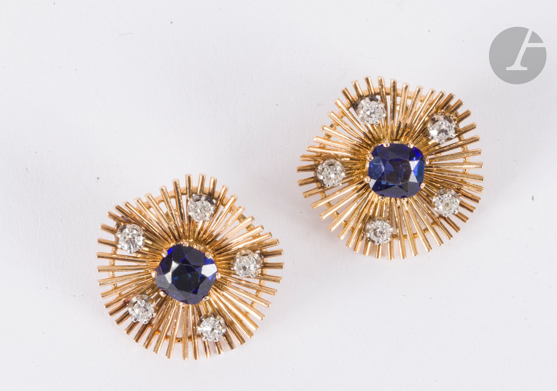 Pair of 18K (750) gold wire ear clips, each set with a synthetic sapphire, embellished with old-cut diamonds on platinum. French work, 1960s. Diameter: approx. 2.5 cm. Gross weight: 17.1 g