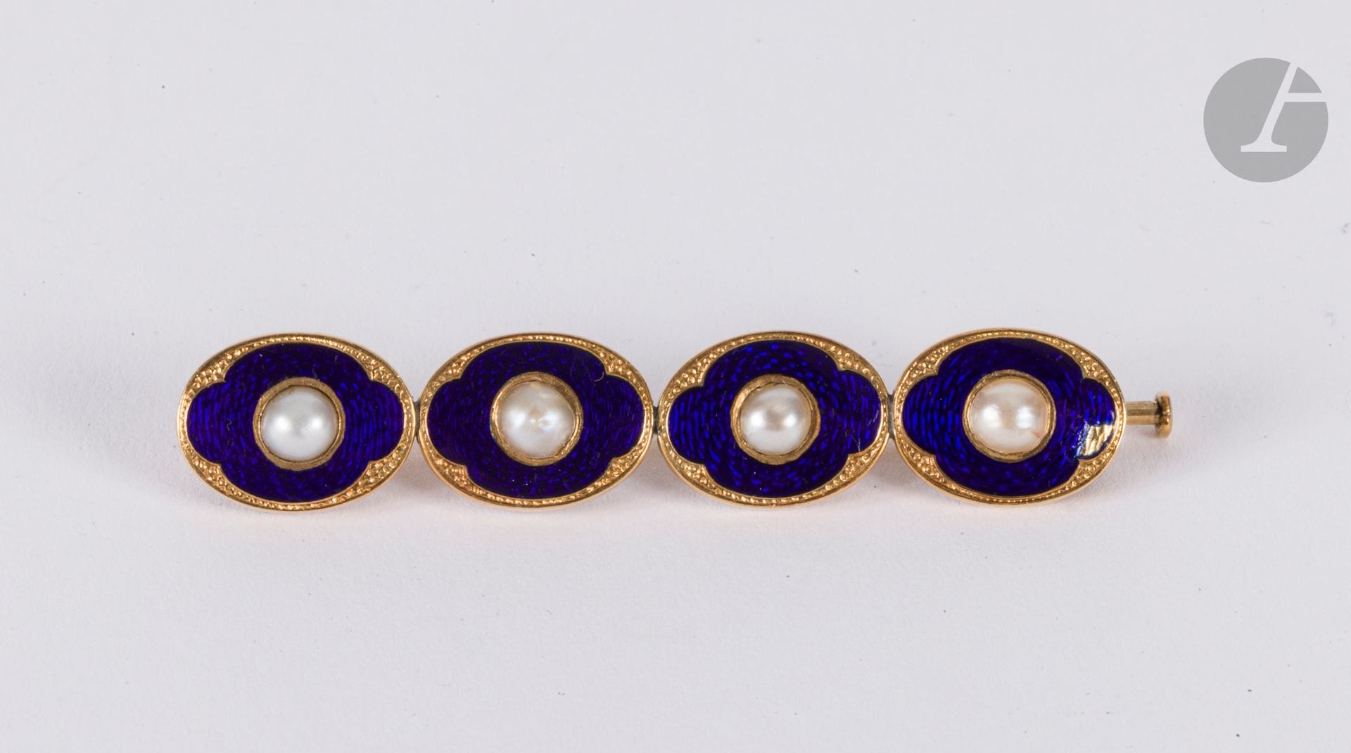 Broche-barrette en or 18K (750), ornée d'une ligne de demi-perles. Travail des années 1920. Longueur : 8 cm environ. Poids brut : 5,9 g