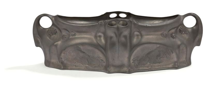 KAYSERZINN u HOUSE FOUNDED JOHANN PETER KAYSE u THE MODEL ATTRIBUTED TO HUGO LEVEN (1874-1956) Les Volatiles Jardinière forming a table centerpiece; the title decoration in relief on both sides. Proof in pewter. Art Nouveau period. Crystal interior missing. Marked with the KAYSERZINN stamp on the reverse. H. 12 cm - L. 43 cm u l. 25 cm