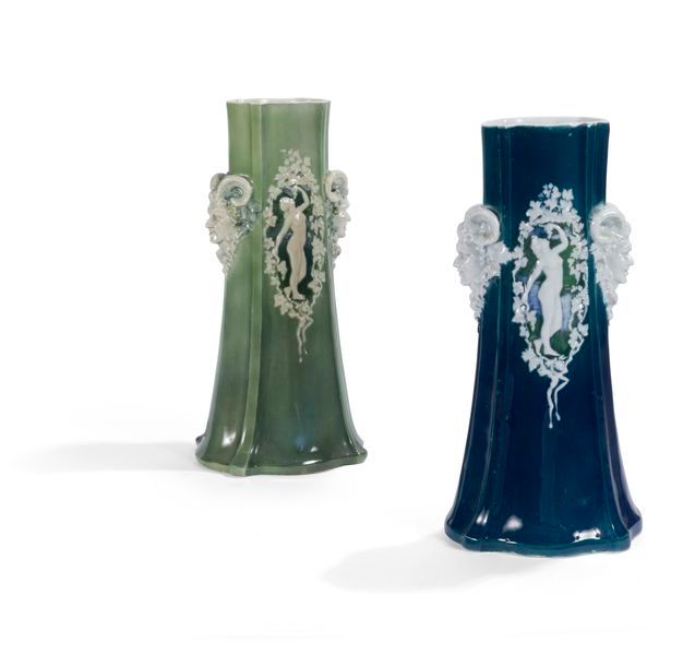 MANUFACTURE DE PORCELAINE D’ALFORTVILLE Bacchanales, 1916 Deux importants vases tronconiques nervurés formant pendants. Épreuves en porcelaine émaillée; l’une en vert, l’autre en bleu marine. Les décors de nus aux grappes de raisin et de têtes de satyre en relief et émaillés blanc. Le vase vert marqué du cachet de la manufacture, le vase bleu daté 7 juin 1916 au revers. H. 40,5 cm