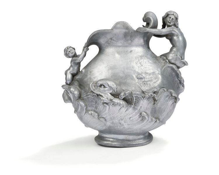 HENRI HUPPE (1855-1911) Woman and child among the waves animated by a dolphin Allegorical vase. Cast pewter proof. Circa 1900. Deformations to the base. Signed H. HUPPE under the female figure. H. 28 cm u L. 27 cm