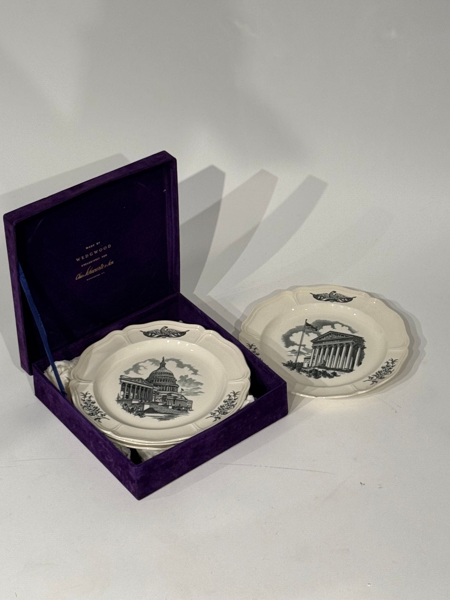 WEDGWOOD - FEDERAL CITY pour 
Service de 4 assiettes commémoratives en porcelaine émaillée à décor d'édifices du pouvoir à Washington. dans un écrin violet.
D. 26 cm.
Egrenures.