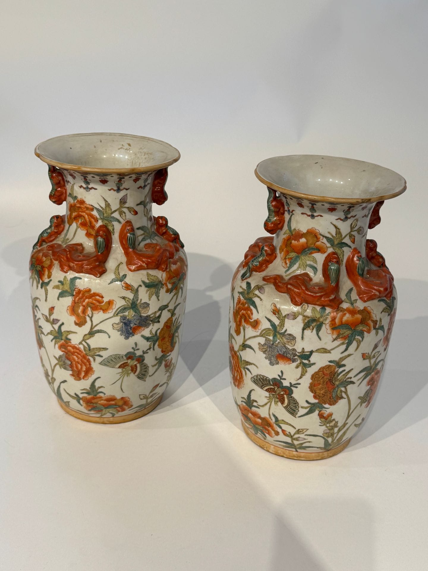 CHINE 
Paire de vases balustre en porcelaine emaillée rouge à décor polychrome de rinceaux et fleurs, et d'animaux appliqués. 
Travail moderne
H. 31 cm