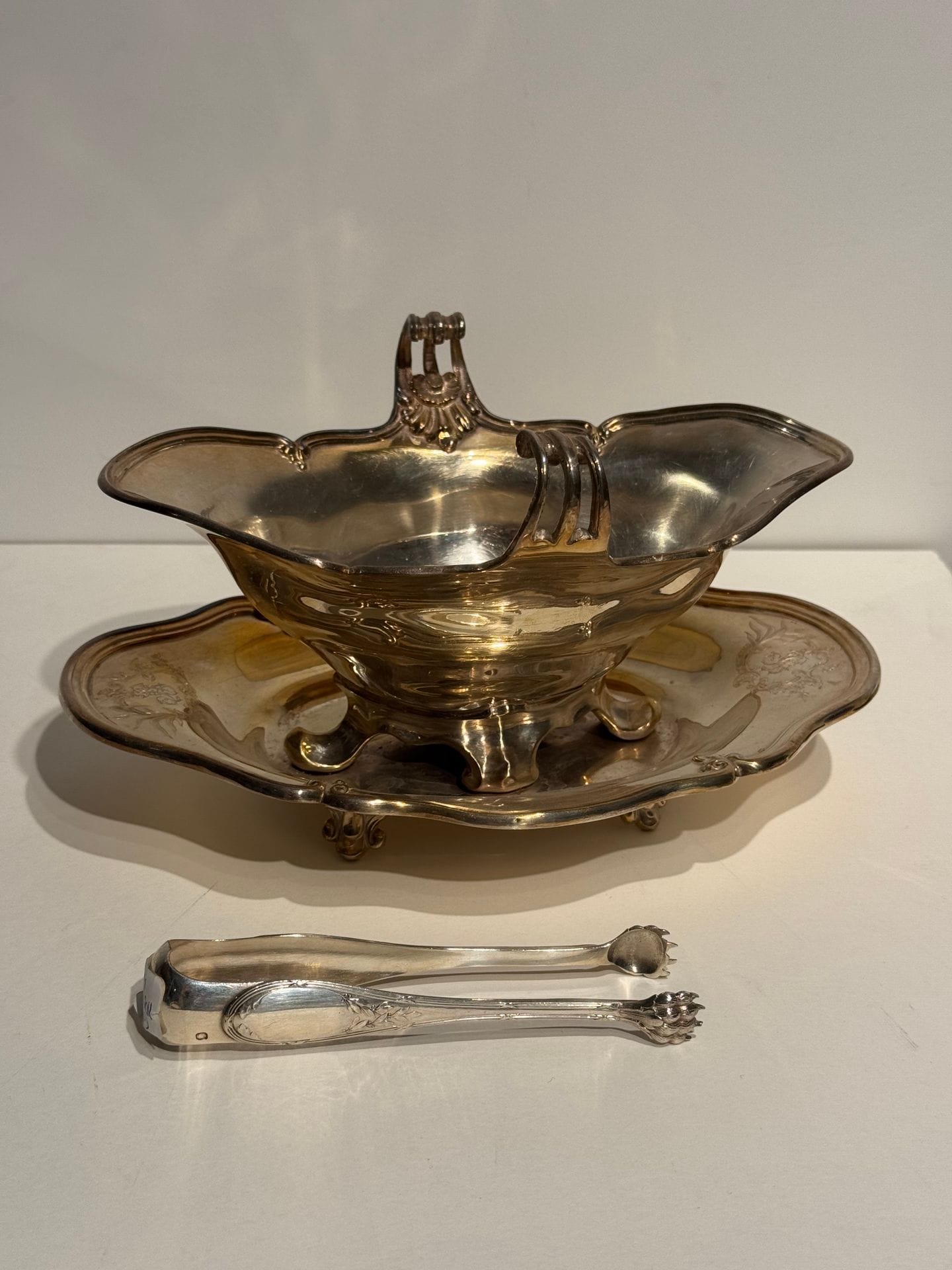 Lot in silver 925/°°° including : 
A sugar tong, 
a Louis XV-style sauceboat on its tray
Net weight: 617 g. 
Two silver-plated crèle spoons.