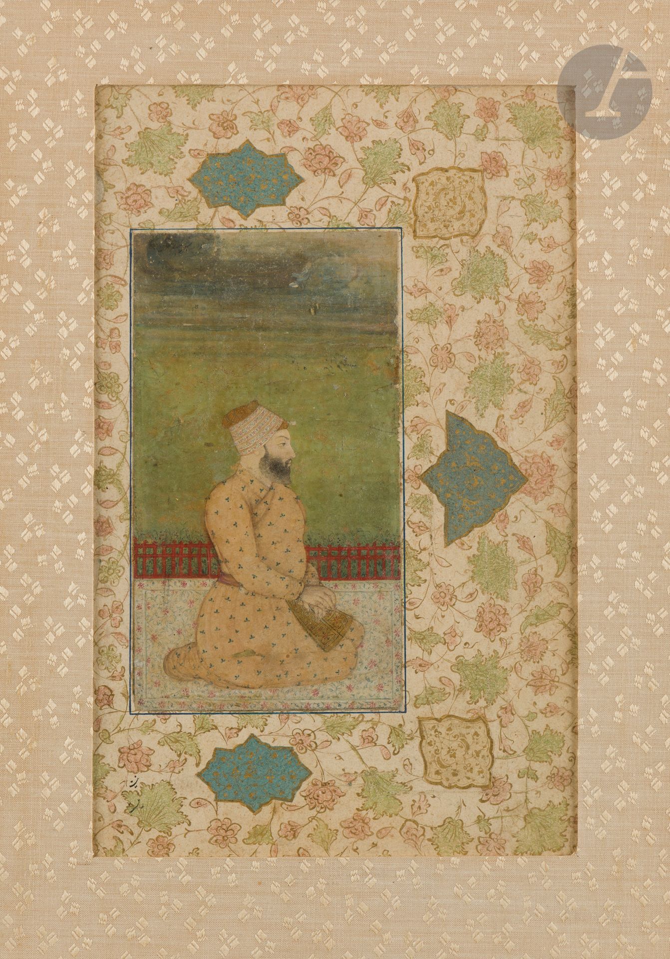 Portrait du Nawab Sabourland Khan, Inde, Delhi, XVIIIe siècle 
Gouache et or sur papier représentant un homme barbu coiffé d'un turban et agenouillé vers la droite sur une terrasse. Il est vêtu d'un jama orangé à semis de fleurettes fermé par une ceinture. Montée en page d'album avec une bordure rouge et une marge à décor peint de rinceaux végétaux dorés pigmentés de vert et rose pastel, des cartouches et des fleurons enluminés sur fond beige ou bleu collés par-dessus. Plusieurs étiquettes au dos du cadre : extraits de notices de catalogues numérotées N° 20.375-4.I53, nom et numéro d'un dépôt Cluzel 029/5 et cachet de douanes françaises. 
Dim. page : 26,6 x 16,6 cm ; dim. peinture : 16,6 x 9,2 cm 
Peinture très usée, pliures, trous, sauts de polychromie, quelques repeints, peinture contrecollée sur carton. 
 
Provenance : 
Ancienne collection Nourhan Manoukian (Constantinople 1906 - Paris 1993). Par descendance.

La marge de cette page d'album est connue sur plusieurs autres oeuvres d'art du livre islamique présentées en vente publique comme deux pages vendues chez Ader Paris le 2 juillet 2024 (lots 193 - 194) ou encore un dessin persan vendu chez Sotheby's, Paris, vente Pierre Le Tan, 17 mars 2021, lot 334. D'autres sont conservées dans les collections nationales comme deux pages indiennes OA 7139 et AOR 4236 du musée du Louvre.
