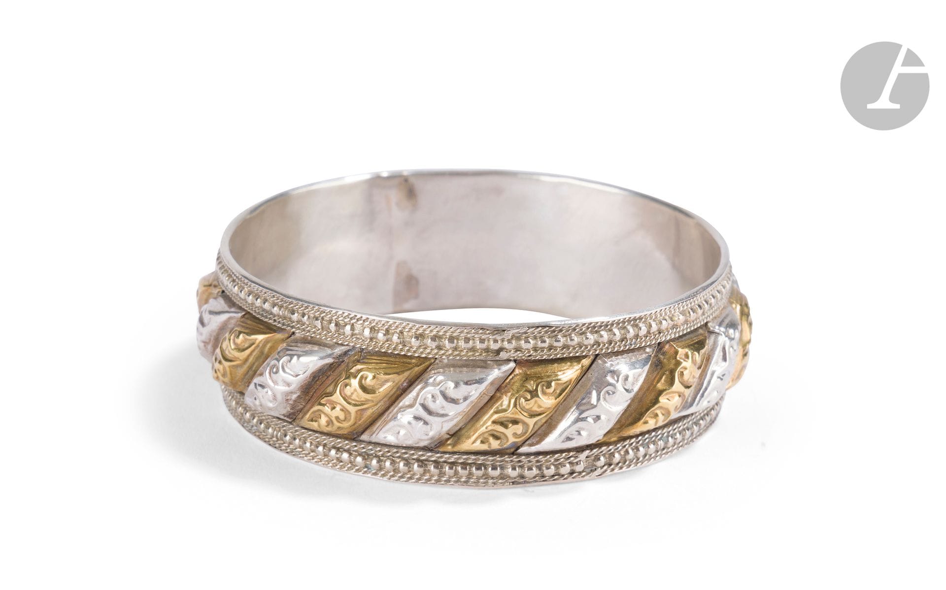 Shams-u qamar bracelet, Northern Morocco, 20th century 
Partially gilded silver shams-u qamar (literally "moon and sun") bracelet with molded gadroons engraved with plant scrolls and flanked by two beaded friezes. 
Inside diameter: 6.8 cm
