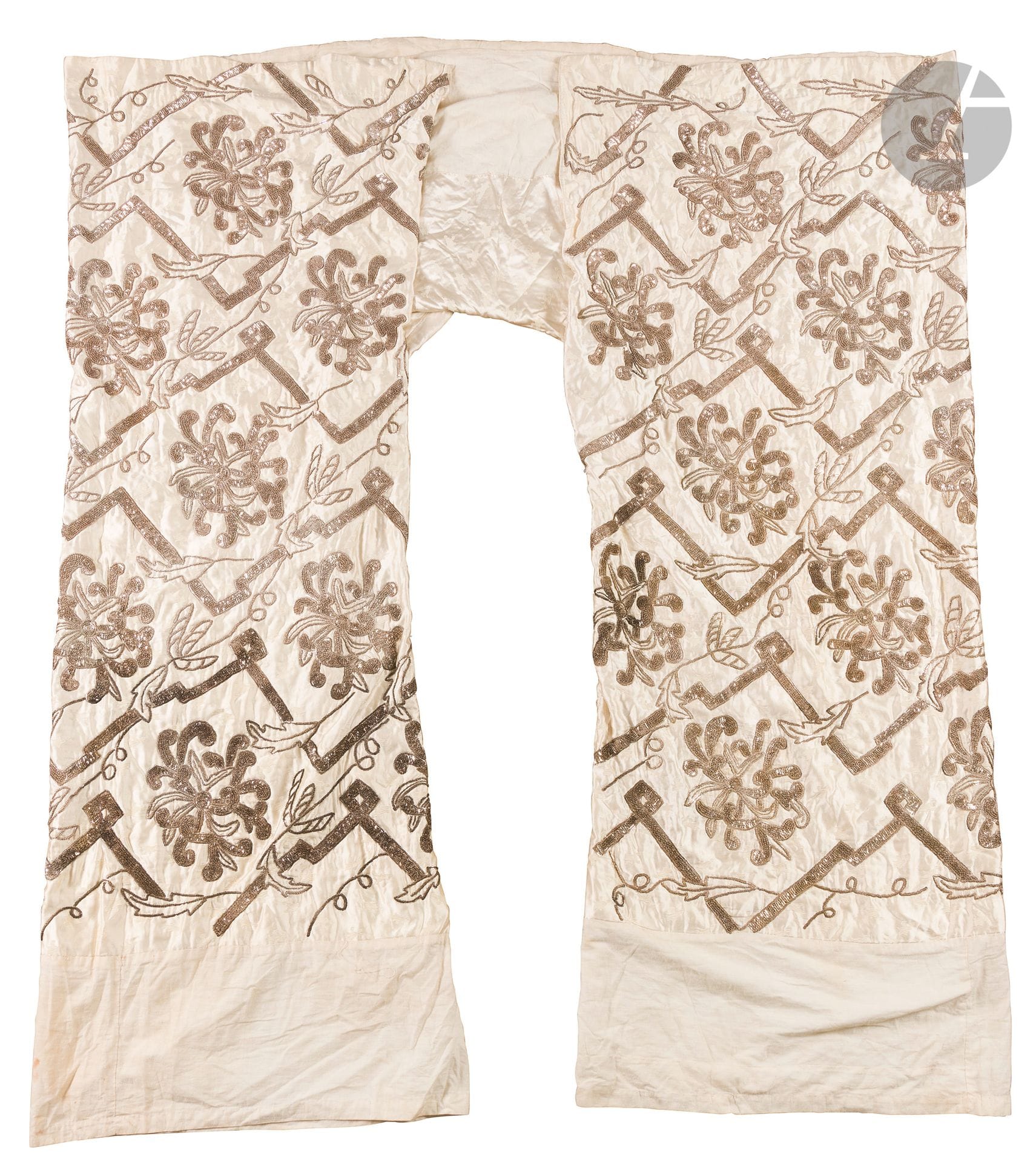 Pantalon de mariée kabous el-gharek ou sarouel, Tunisie, début du XXe siècle 
Large pantalon en satin de soie écrue brodée d'un semis de petites fleurs en fils de soie et de cannetilles et sequins d'argent dessinant des lignes brisées et de larges motifs floraux, le fond à semis de fleurettes brodées de fils. Empiècements de coton cousus en bas des jambes et à la taille, et doublure de coton. 
Env. 156 x 165 cm 
Quelques taches, oxydation de certains éléments en argent.

Ce pantalon bouffant et très large est un élément du costume traditionnel de la mariée tunisienne, juive comme musulmane appelée marsaoui. Il est associé à un corsage qui couvre le buste de la mariée. Un exemple similaire se trouve au Musée d'Art et d'Histoire du Judaïsme (Inv. 2002.34.001.1-2).