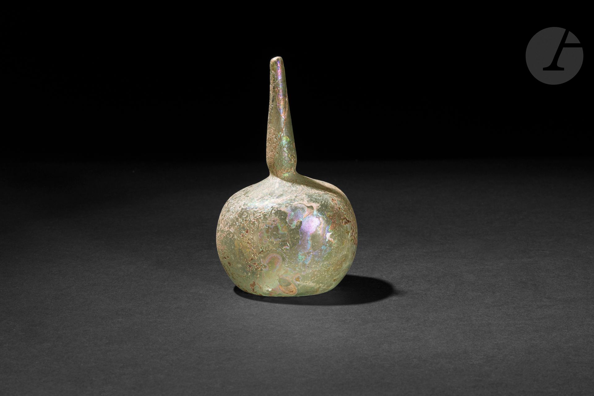 Glass qumqum aspersor, Bilad ash-Sham (Greater Syria), 11th - 13th century 
Translucent glass, slightly flattened globular body topped by a high tubular neck. 
Height: 12.5 cm 
Significant irisations, restoration to neck.

Very similar qumqum are preserved in the al-Sabah Collection in Kuwait under inventory no. LNS 38 G, or in the National Museum in Damascus (no. 642 A).
