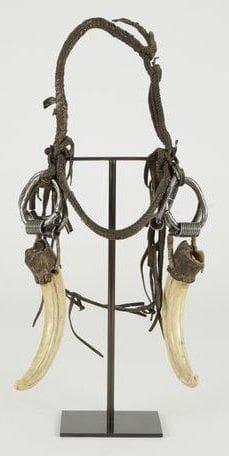 SURMA/MURSI (Ethiopie) Ornement de tête. Magnifique coiffure en cuir et fer à laquelle sont accrochés 2 dents de phacochères. Les 2 sexes arborent cette parure, elle souligne le courage masculin et le statut de la femme. Longueur des dents: 19 cm Biblio: A.Van Cutsem, Parures de tête, 5 continents, 2010, n°80