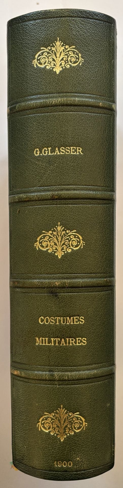 GLASSER.
Costumes Militaires. Catalogue des principales suites de costumes militaires français parues tant en France qu’à l’étranger depuis le règne de Louis XV jusqu’à nos jours et des suites de costumes militaires étrangers parues en France. Par un membre de la Sabretache.
Paris : Henri Vivien, 1900. — Grand in-8, 248 x 160. Demi-chagrin bleu à coins, dos à 4 faux nerfs orné, tête dorée, non rogné, couverture et dos conservés (reliure du temps).

Édition originale de cette bibliographie de référence sur les costumes militaires.

Un des 15 exemplaires sur papier du Japon, seul tirage de tête avec 15 hollande et 15 vélin. Il renferme un état en noir et un état colorié à la main des 4 planches hors texte d’après Job, Hoffmann, Martinet et Weiland.

Envoi autographe signé de l’auteur :
à Monsieur Godet, en souvenir reconnaissant

Bon exemplaire en grand papier.
Dos passé, frottements aux charnières.

Provenance :
M. Godet, avec envoi de l’auteur.