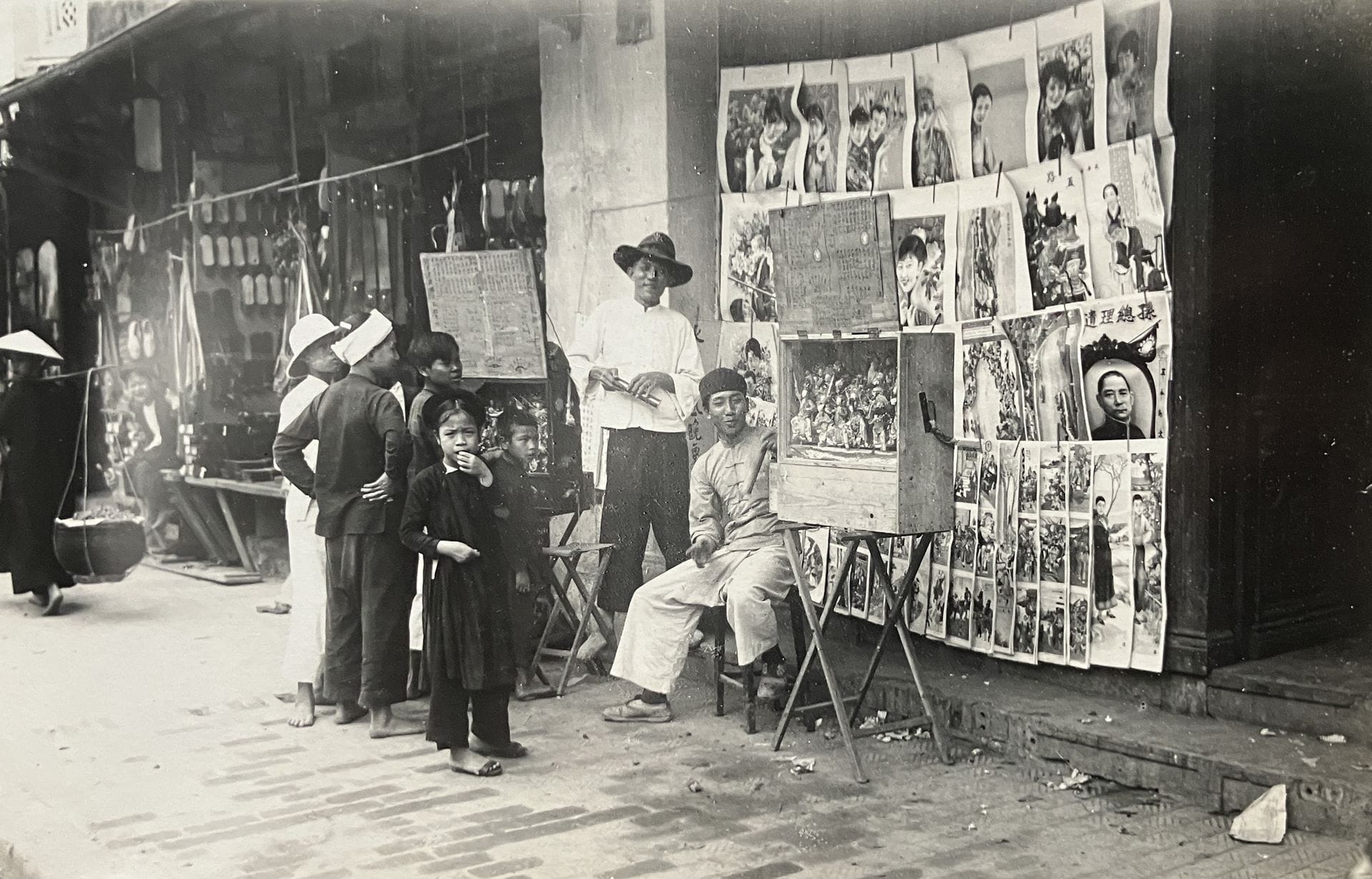 Unidentified photographer 
Vietnam, c. 1920-1930. 
Hanoi. Native neighborhood. Doumer Bridge. Red River. Sampans and rafts. Puppet merchants. Traveling comedians. Tonkin. Cam-Pha mines. Annamite tombs. Rice transplanting. Religious architecture. Along Bay. Oil merchant. Haïphong. Hué. Temple of Confucius. Royal Elephants. Perfume River. Mekong River. Laotian musicians. Ventiane. Pha That Luang. Women of the Upper Mekong. 
Oblong in-4 album, with woven dragon figure on cover, composed of approximately 180 vintage silver prints mounted on cardboard. Numerous handwritten captions in gilded felt-tip pen on the mounts. 
Sizes: 9.5 x 14.5 to 16 x 21.5 cm