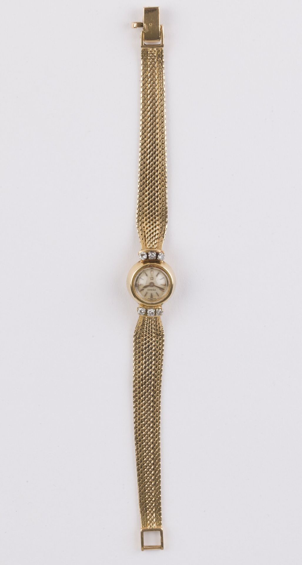 OMEGA
ANNÉES 40
Petite montre de dame duoplan en or jaune 18K (750), petits diamants, remontoir au dos. 
Numérotée 246047.
Diam. 15 mm 
Poids brut: 28,28g