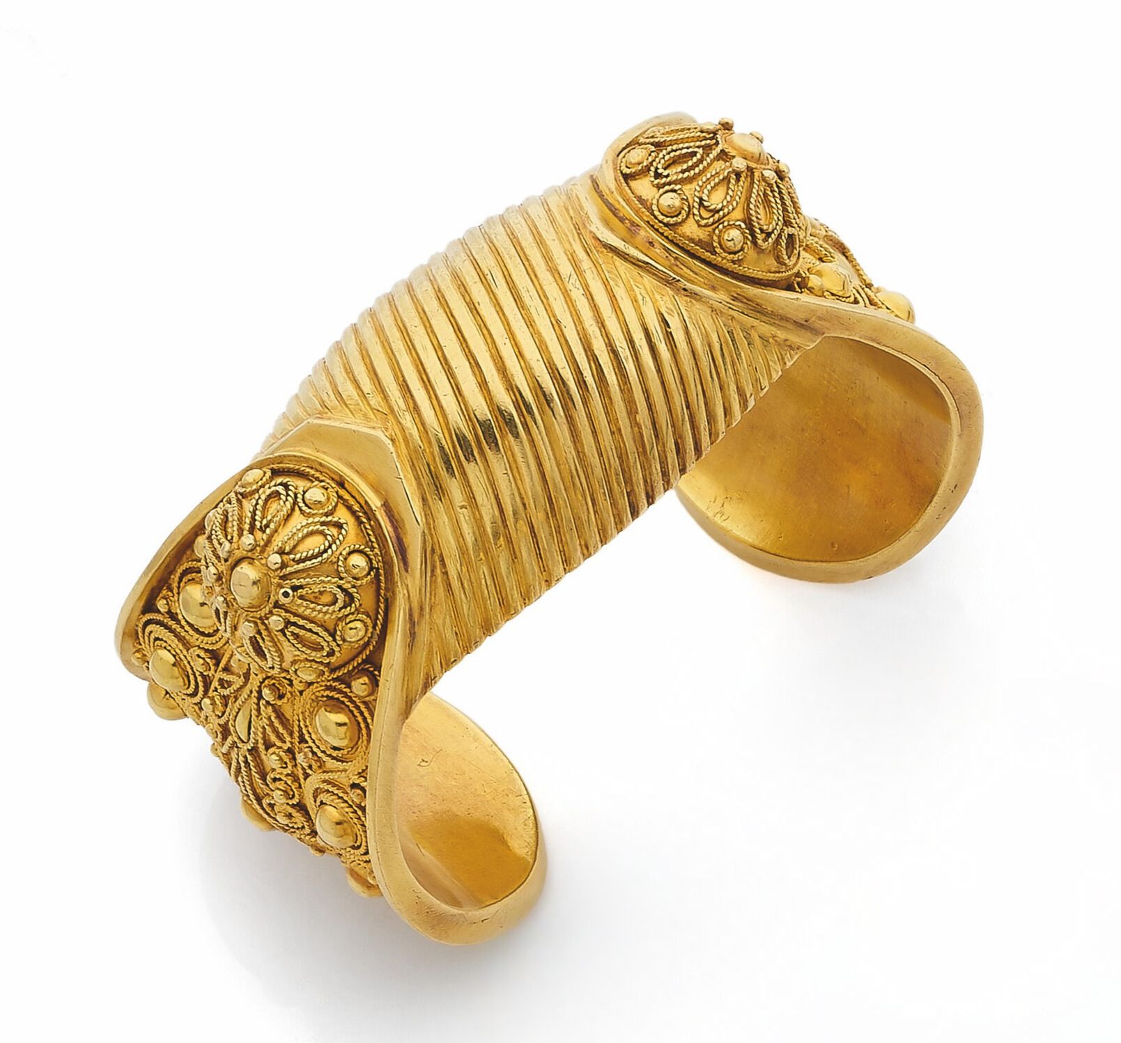 Large 18K (750) gold bracelet adorned with filigree motifs of meanders, palmettes and stylized flowers. Asian work. Dimensions: 16.5x3.7cm approx. Weight: 109.9g (missing)
A gold bracelet

 Suzanne Belperron was inspired by this type of bracelet to create one in smoky quartz.