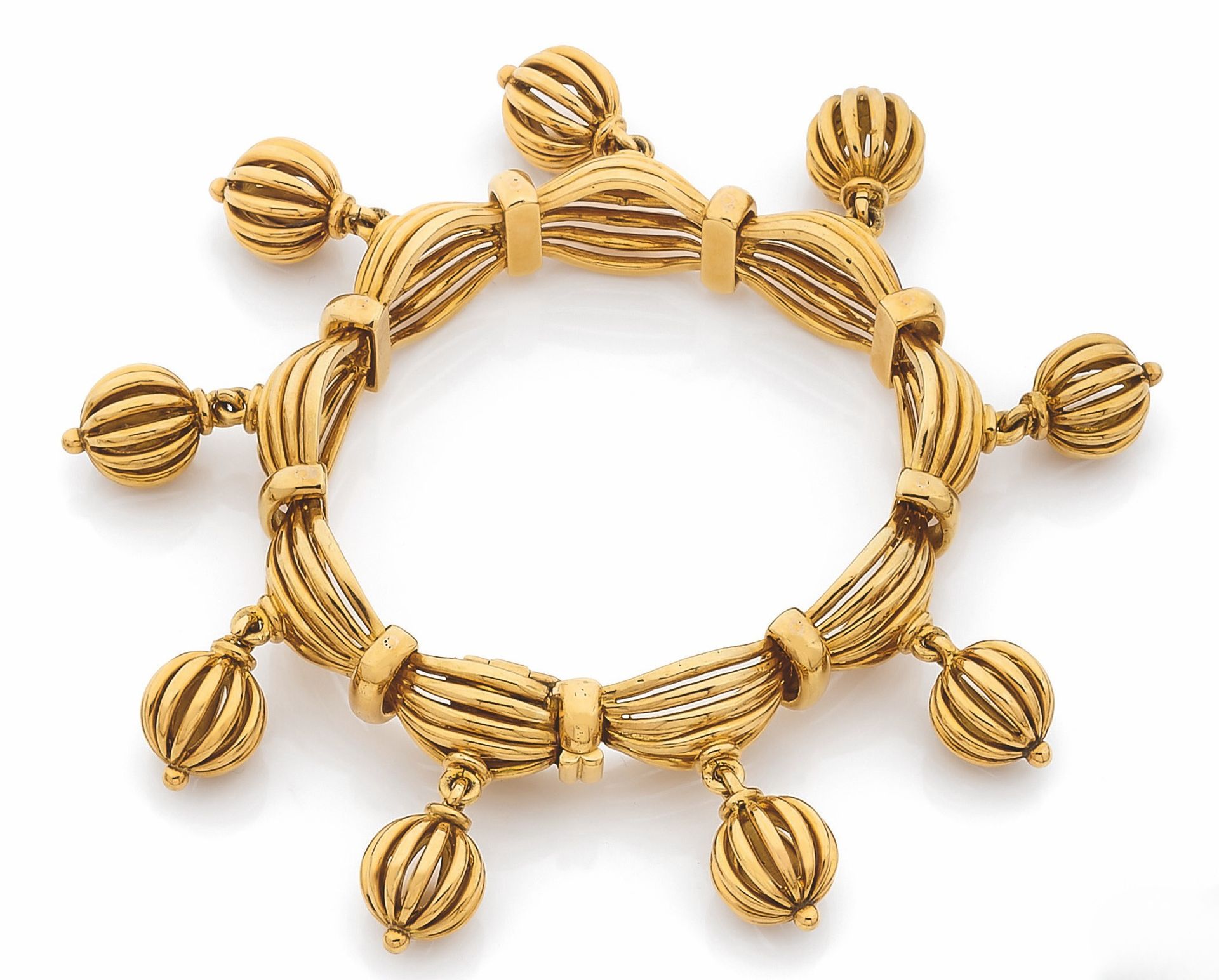 BOUCHERON
Articulated bracelet in 18K (750) gold wire, punctuated with gold wire bells. Signed and numbered. French work, 1950s. Kept in its case. Length: 16.5cm approx. Weight: 89.2g
A Boucheron bracelet