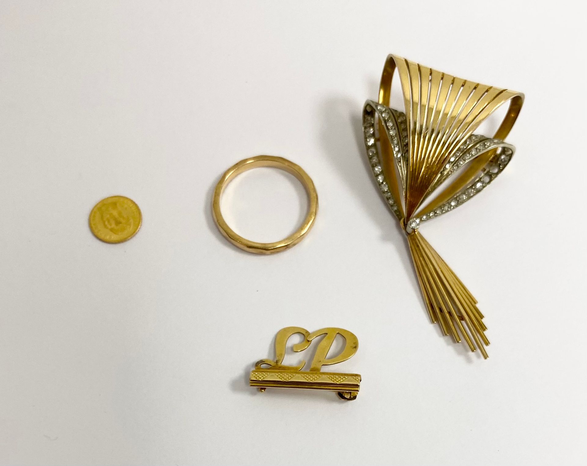 Lot en or comprenant : une alliance en or jaune 750/°°° facetté.

- Une broche en or jaune 750/°°° à décor de diamants taille brillant de la maison Calderoni Gioelli Milano.

- Une broche monogrammée LP en or jaune 750/°°°.

- Une pièce Mexique, MAXIMILIEN Empereur en or jaune 1865.

Poids brut : 16.8 g



Frais acheteur pièces et lots en or : 9,6% TTC -  8% HT 



Frais acheteur lots d'argenterie : 20% TTC - 16,67% HT