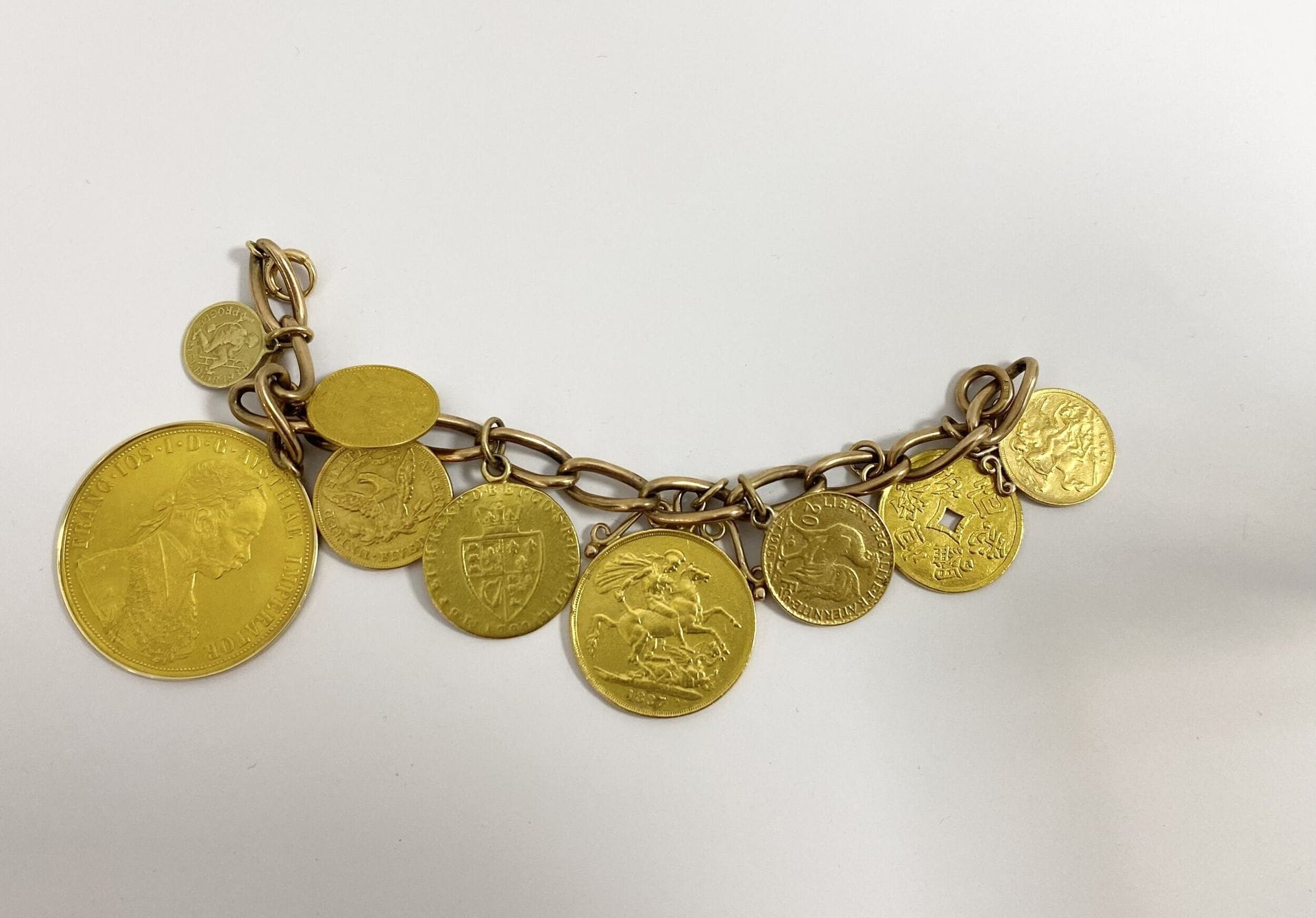 Bracelet en or jaune 375/°°° retenant des pièces d'or en pendeloque.

- Une pièce de 20 Francs or 1905.

- Un Souverain or Edouard VII.

- Une pièce chinoise en or jaune.

- Un Souverain Or 1887 Victoria Tête Jubilée. 

- Une Livre Georges III, guinée. 

- Une Liberty Head 1880.

- Une pièce 1 Ducat Or François Joseph 1915.

- Une pièce de 4 Ducat Or François Joseph 1915.



Poids total : 94,1 g



Frais acheteur pièces et lots en or : 9,6% TTC -  8% HT 



Frais acheteur lots d'argenterie : 20% TTC - 16,67% HT