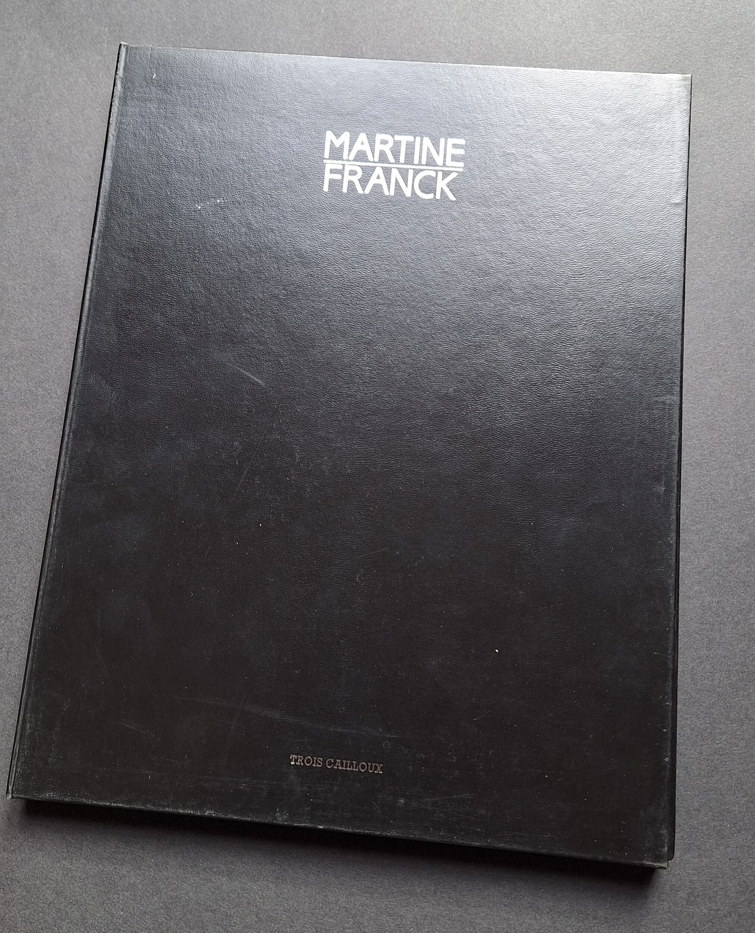 FRANCK, MARTINE (1938-2012) [Signé]
BONNEFOY, YVES
Martine Franck, Portraits.
Éditions des Trois Cailloux, 1988. 
Portfolio 31 x 23 cm, tiré à 720 exemplaires numérotés et signés par Martine Franck. Texte introductif de Yves Bonnefoy. 18 planches photographiques par Martine Franck. Etui noir de l'éditeur titré en lettres argentées.