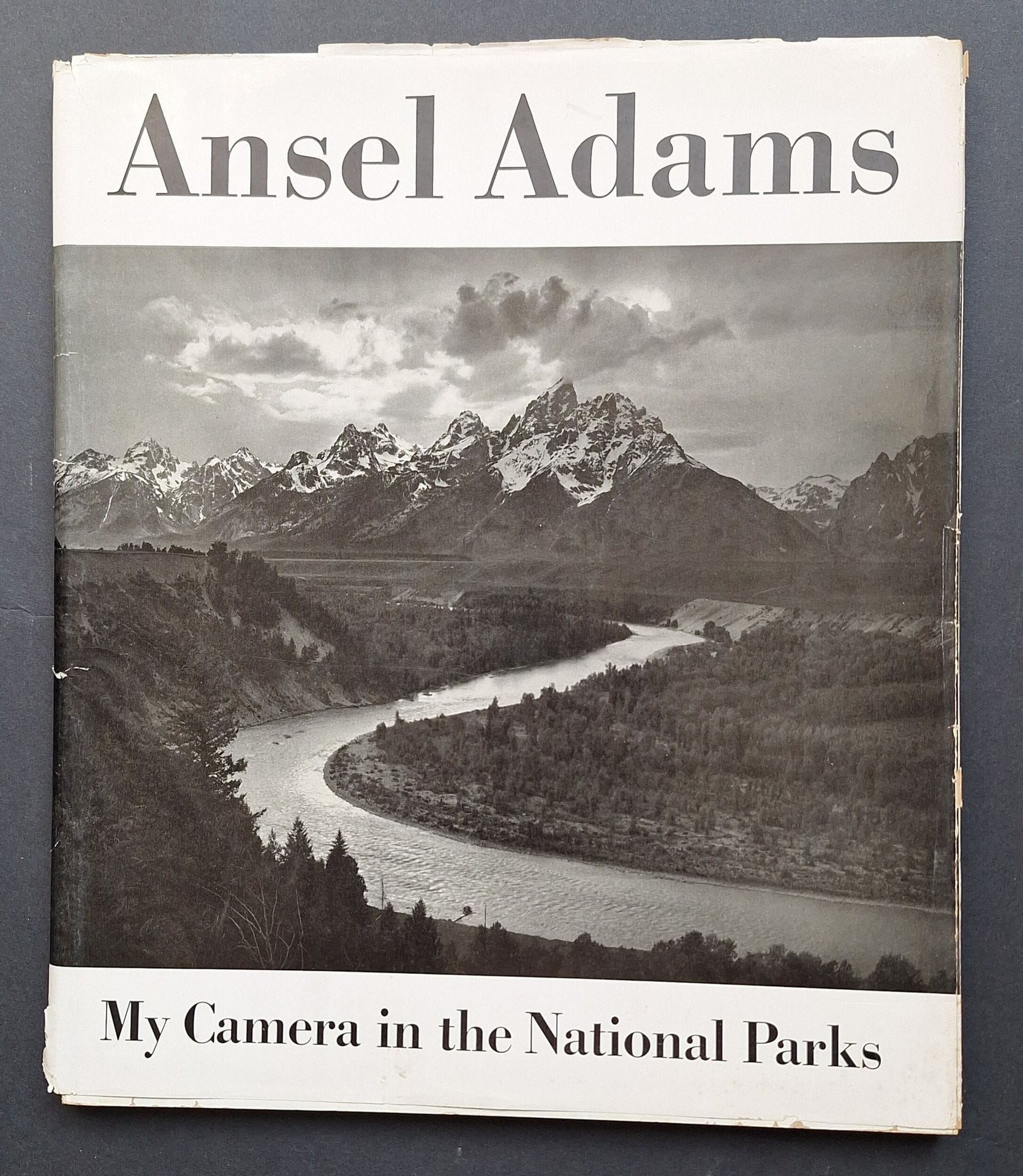 ADAMS, ANSEL (1902-1984) [Signé]
My Camera in the National Parks.
30 photographs, with interpretative text and informative material on the Parks and Monuments and photographic data.
Virginia Adams, Yosemite National Park and Houghton Mifflin Company, Boston, 1950.
In-folio (37 x 30 cm). Édition originale, signée par Ansel Adams en page de garde. 98 pp. Cartonnage blanc titré en noir, sous sa rare et fragile jaquette conservée (accidents à la jaquette). Reliure spirale d'éditeur.