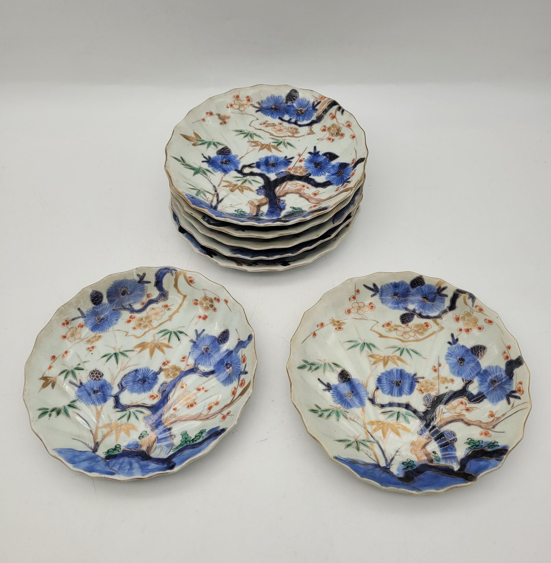 7 porcelain plates, Japan, 19th century
In molded porcelain imitating a shell, decorated with a flowering tree in blue underglaze and other polychrome plants overglaze.
Diameter: 18.5 cm